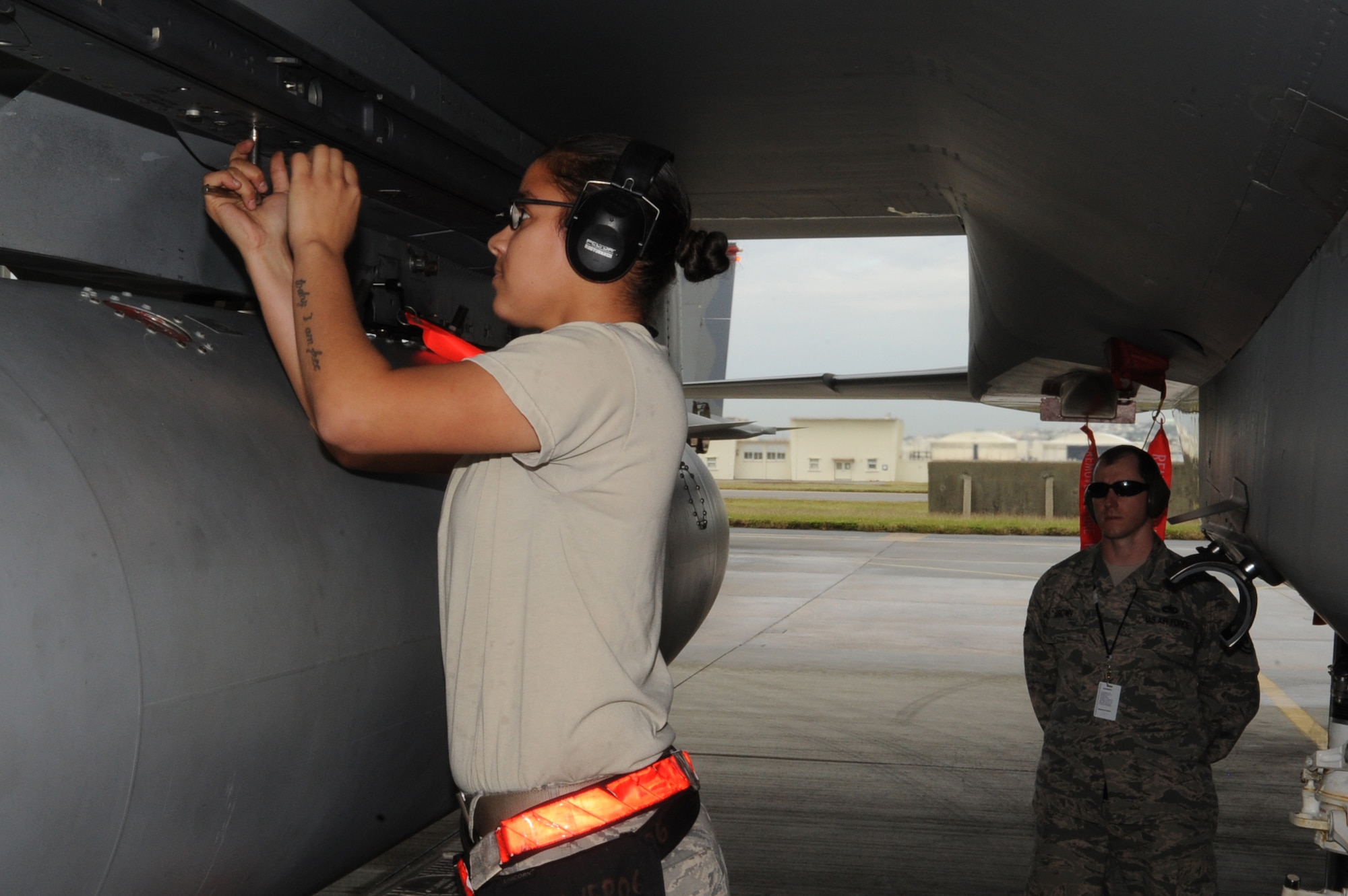 U.S. Air Force Airman 1st Class Frances Crespo, 18th Aircraft Maintenance Squadron weapons load crew member, works on the LAU-128 launcher while Tech. Sgt. Zachary Brown, 18th AMXS evaluator, observes procedures to ensure safety during the quarterly weapons loading competition at Kadena Air Base, Japan, Nov. 17, 2014. Competitions promote teamwork among weapons load crews and allow supervisors to evaluate their teams' strengths and weaknesses while under pressure. (U.S. Air Force photo by Airman 1st Class Zackary A. Henry/Released)