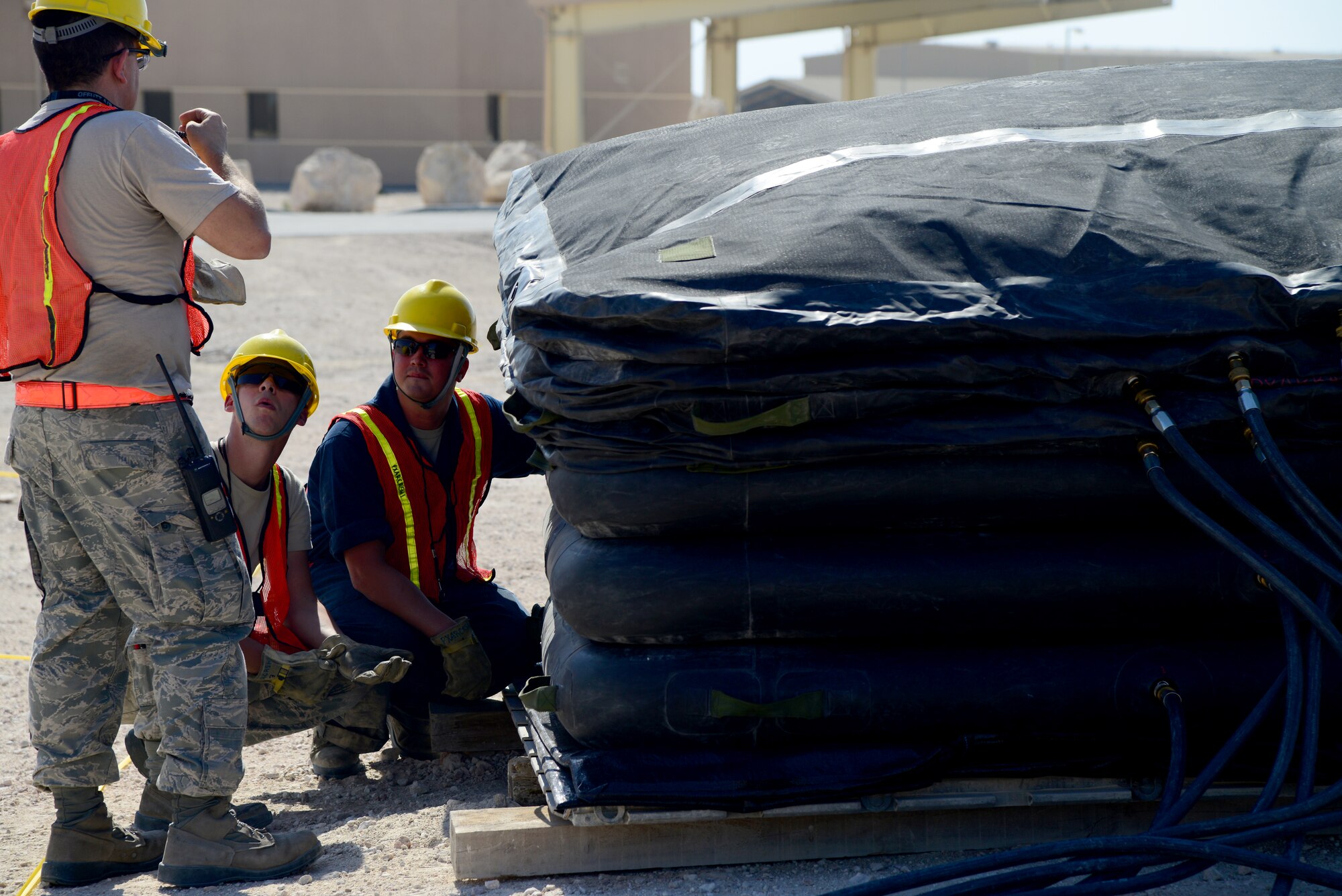 U.S. Air Force Airmen from the 379th Expeditionary Maintenance Group Crashed, Damaged, Disabled Aircraft Recovery (CDDAR) team wait for an airbag to inflate during an exercise, Nov. 11, 2014, at Al Udeid Air Base, Qatar. The air bags are just one of the many tools available to the team to assist them in repairing damaged aircraft. (U.S. Air Force photo by Senior Airman Kia Atkins)