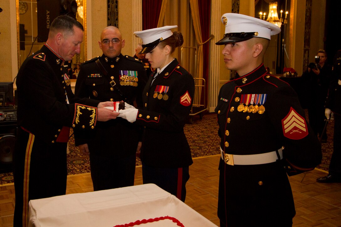 Maj. Charles D. Godwin, Commanding Officer of Recruiting Station Milwaukee, presents the birthday cake to the youngest Marine, Cpl. Victoria McKenzie, during RS Milwaukee’s Birthday Ball ceremony Nov. 15, 2014.  The birthday cake is passed from the oldest to the youngest Marine present, symbolizing the passing of history and traditions to the next generation.  Cpl. McKenzie is the Operations Clerk for RS Milwaukee.