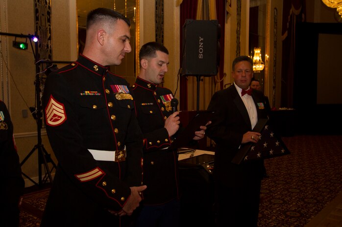 Sgt. Anthony Palaia, a recruiter with Recruiting Substation Green Bay, reads a letter of appreciation from the mayor of Green Bay during the Marine Corps birthday ball in Milwaukee, Wis., Nov. 15, 2014.  Staff Sgt. Charles Schneider received the letter along with a flag that was flown over city hall as recognition for his active role within the community of Green Bay.