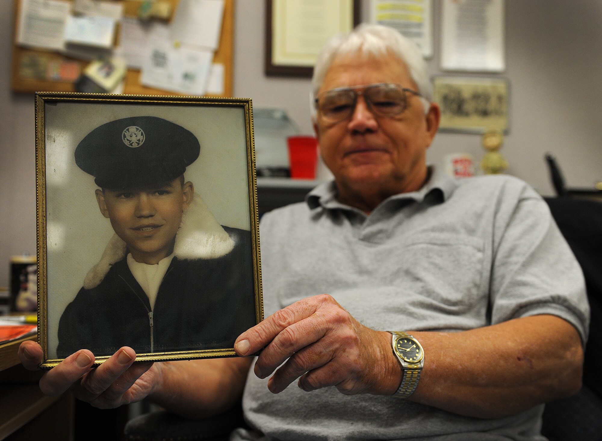 Terry Lee holds a photo of himself from 1962 on Nov. 10, 2014, at Keesler Air Force Base, Miss. Lee enlisted in the Air Force as a B-52 Stratofortress maintainer when he was 18 years old. Lee contributed to the success of the 24-hour operations at McCoy Air Force Base, Fla., by ensuring aircraft were properly maintained during the Cuban Missile Crisis. Lee works as a K-Mar Industries illustrator at Keesler AFB. (U.S. Air Force photo/Senior Airman Holly Mansfield)