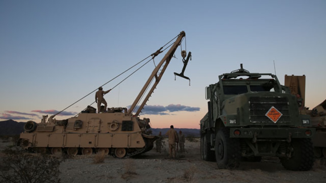 Marines with Company A, 1st Tank Battalion, 1st Marine Division work together with 1st Combat Engineer Battalion Marines to offload a mine-clearing line charge from a seven-ton truck to be used in the Tank Mechanized Assault Course during the Integrated Training Exercise aboard Marine Corps Air Ground Combat Center Twentynine Palms, Calif., Nov. 2, 2014. Company A Marines also worked with infantry, mortars, and air support during their assault.