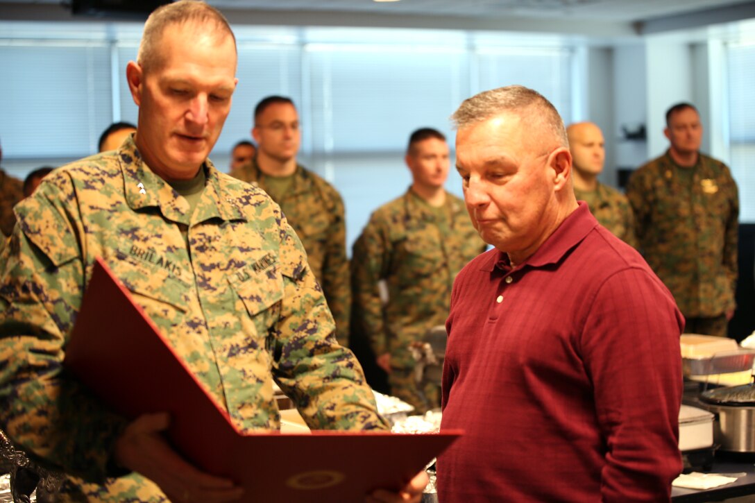 Michael J. Styka, deputy head of enlisted recruiting operations at Marine Corps Recruiting Command, receives an award from Maj. Gen. Mark A. Brilakis, Commanding General, MCRC, for his 45 years of service to the Marine Corps during the MCRC Harvest Feast here today. Styka retired from the Marine Corps as a Master Gunnery Sgt. in 2001 after 32 years on active duty and now retires from MCRC as a civilian after 13 years.