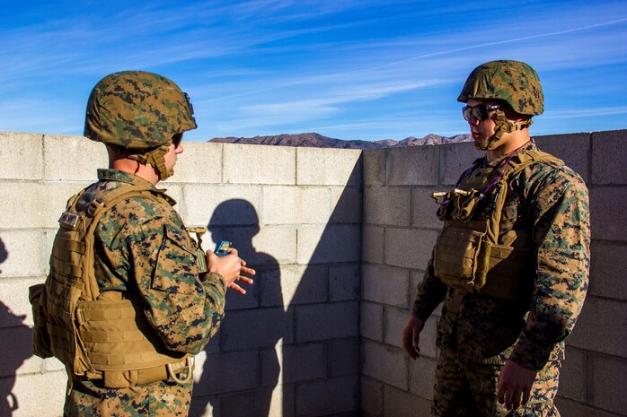Corporal Ronald Peebles, right, a motor transport operator with Headquarters Battery, 5th Battalion, 11th Marine Regiment, instructs another Marine on proper grenade throwing techniques during a hand grenade training exercise aboard Marine Corps Base Camp Pendleton, Calif., Nov. 18, 2014. The event served as a way for 5/11 Marines to refresh their basic fighting skills and to maintain their combat mindsets.