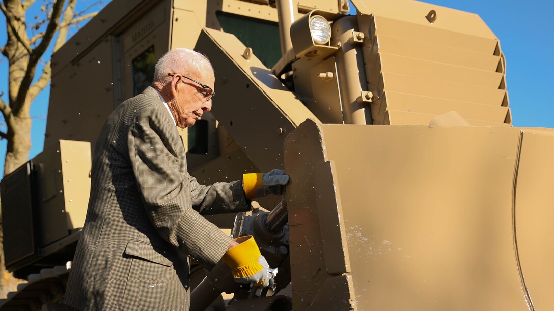 Retired Col. James “Rip” Harper christens a D7G bulldozer used in Operations Desert Shield, Desert Storm and Iraqi Freedom, outside the Naval Support Activity Portland after 6th Engineer Support Battalion’s battle color rededication ceremony in Portland, Ore., Nov. 15, 2014.The battalion celebrated the 70th anniversary of its formation with a rededication ceremony and paid homage to Harper, the battalion’s first adjutant. Harper served as the unit’s first adjutant as a first lieutenant in 1944, when the unit was formed in Guadalcanal during World War II.