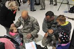 Master Sgt. Matthew Hourigan, left, and Tech Sgt. Jacob Harper greet their children in Louisville, Kentucky, after the Airmen returned from a deployment, Nov. 19, 2014. 