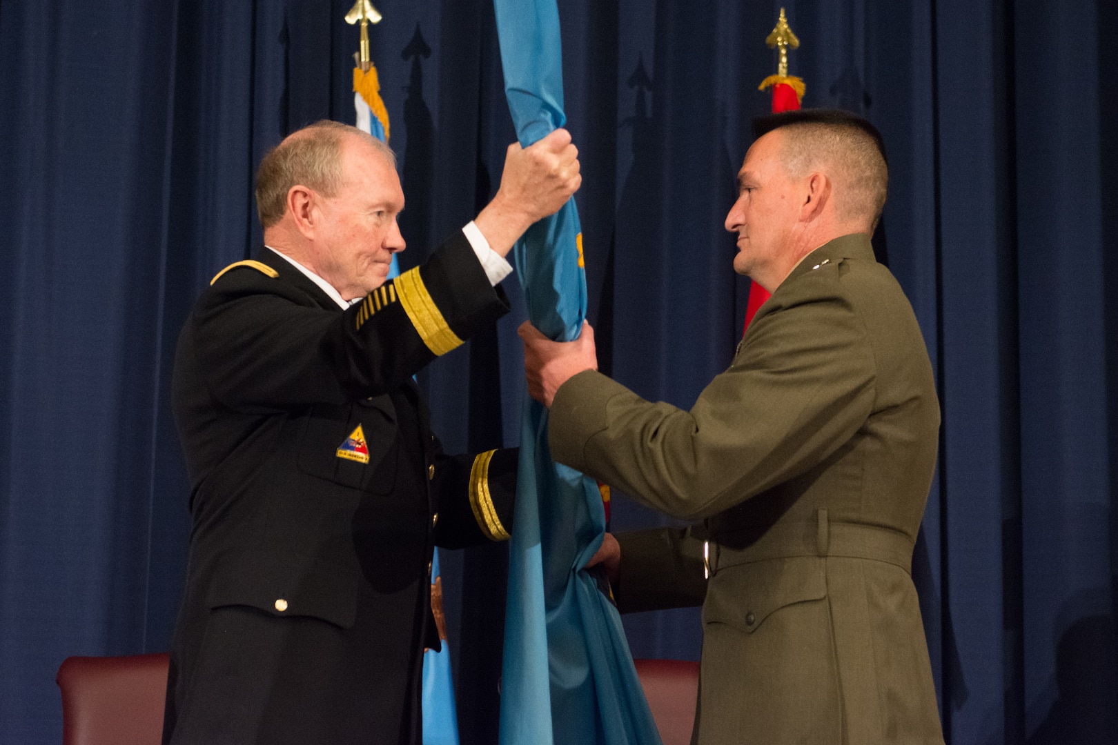 Chairman Dempsey passes the NDU flag to Maj. Gen. Padilla. 