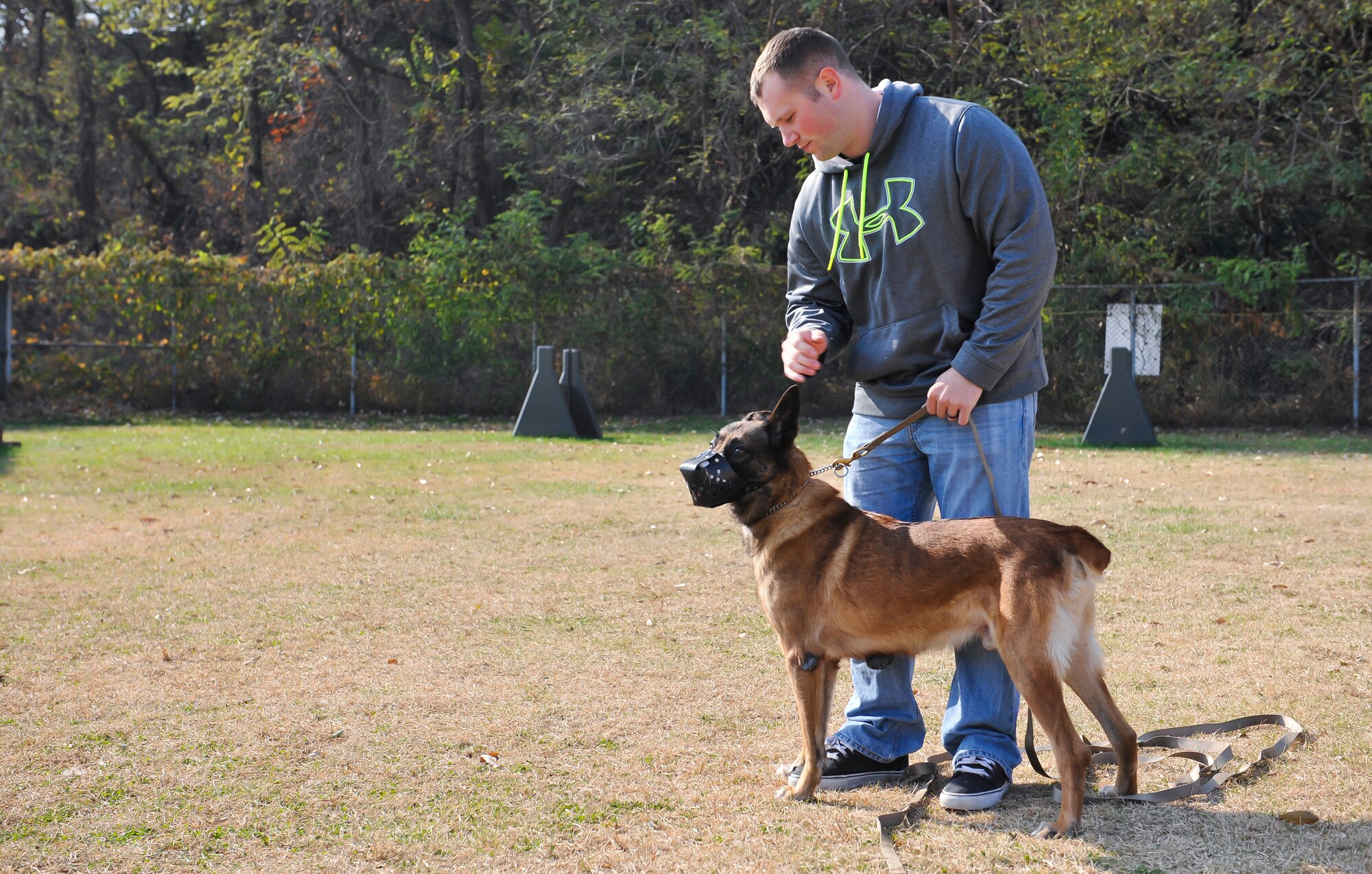 Senior Airman Noah Hyatt, 51st Security Forces Squadron military working dog handler, pets Fficher, 51st SFS MWD, as they work on an adoption video Nov. 14, 2014 on Osan Air Base, Republic of Korea. The month long adoption process begins when an MWD becomes eligible for retirement. (U.S. Air Force photo by Senior Airman David Owsianka)