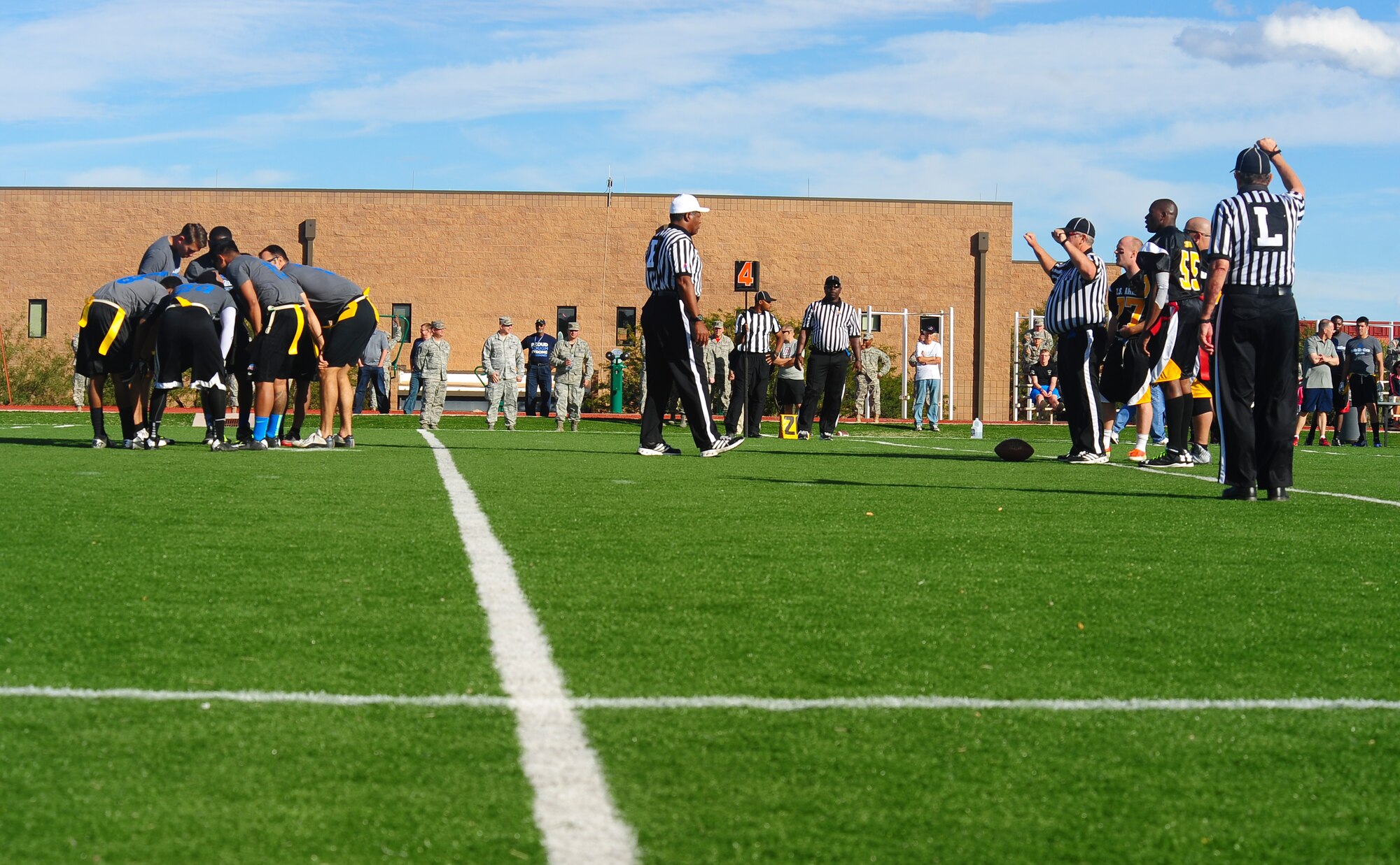 Davis-Monthan Air Force Base Desert Lightning Team members huddle during the annual Turkey Bowl flag football game at Fort Huachuca, Ariz., Nov. 14, 2014. Airmen from Davis-Monthan Air Force Base competed against soldiers at Fort Huachuca, to build esprit de corps and collect food for a community food locker. (U.S. Air Force photo by Staff Sgt. Angela Ruiz/Released)