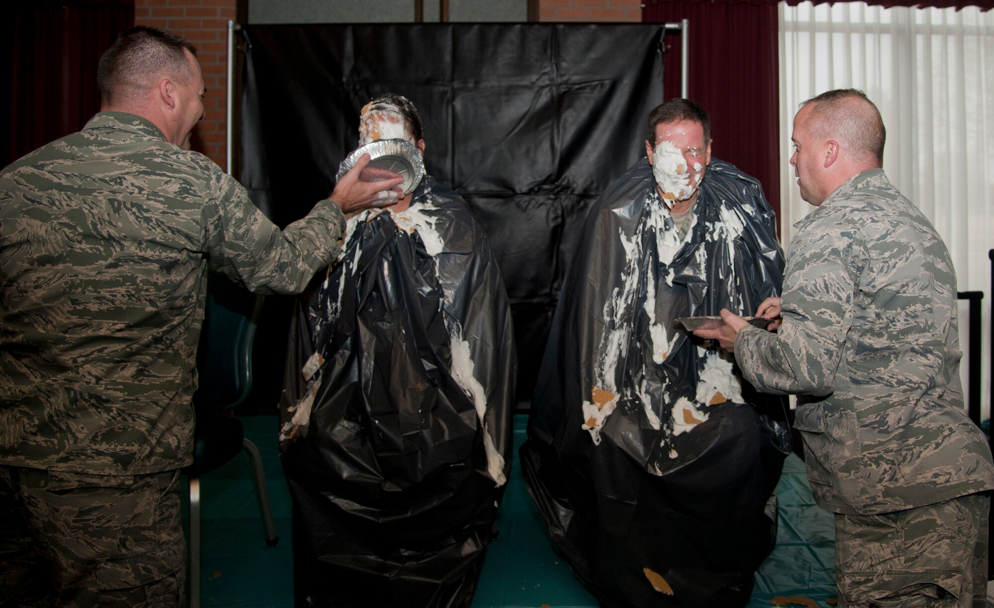 VANCE AIR FORCE BASE, Okla. – (Left to right) Maj. John Klohr, the 71st Logistics Readiness Squadron commander, pies Master Sgt. Deniece Miller, the 71st Operations Support Squadron NCO in-charge of air traffic control training, while Chaplain (Capt.) Jon Smithley, a 71st Flying Training Wing chaplain, pies Col. David Chiesa, the 71st Medical Group commander, at the Vance Collocated Club during the pie-in-the-face fundraiser for the Combined Federal Campaign Nov. 14.  The fundraiser raised $457. (U.S. Air Force photo/Staff Sgt. Nancy Falcon)