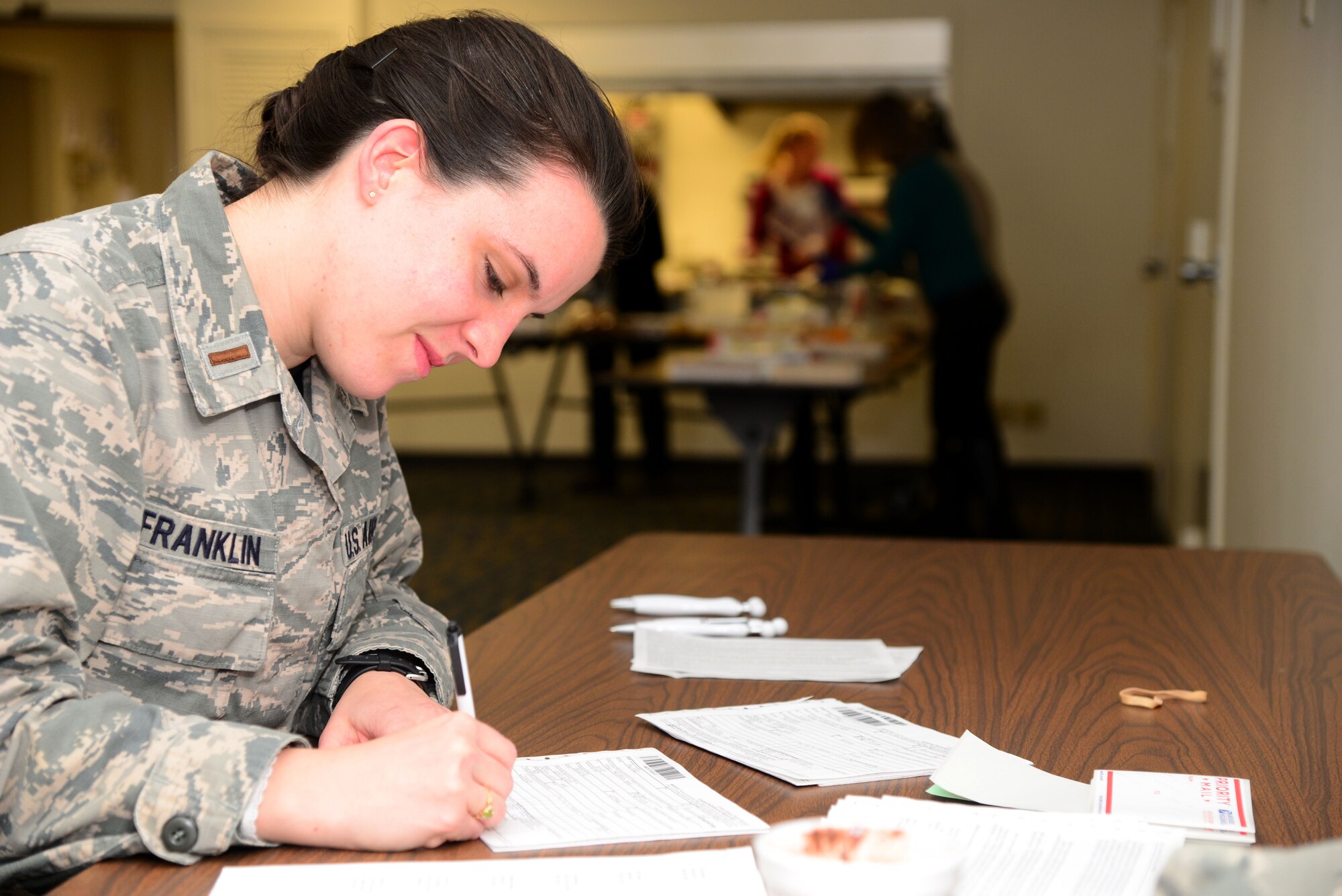 VANCE AIR FORCE BASE, Okla. -- 2nd Lt. Jessica Franklin, with the 71st Operations Support Squadron, fills out a customs form for a box of cookies during Operation Cookie Cutter in the Community Chapel Activity Center Nov. 14. For more than 20 years, members of Team Vance have mailed cookies and other sweets to deployed Vance Airmen. Twenty-two boxes filled with about 150 cookies each will make their way to Team Vance’s deployed warriors. (U.S. Air Force photo/Senior Airman Frank Casciotta))