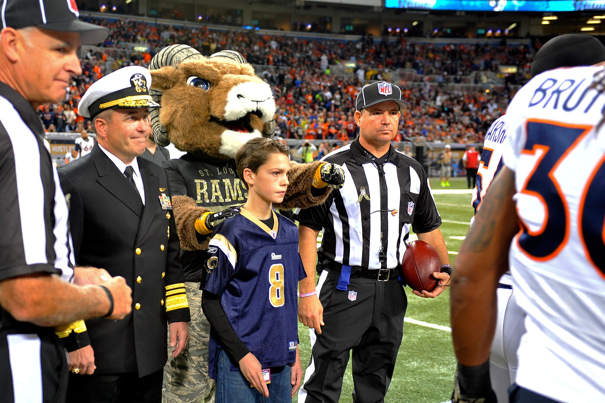 U.S. Navy Vice Adm. Andy Brown, the military guest of honor for Military Appreciation Day, joins the St. Louis Rams mascot and referees before the pregame coin toss at the Rams versus Broncos football game, Edward Jones Dome, St. Louis, Nov. 16, 2014. The day included honoring wounded warriors and honor guards from every branch of the Armed Forces presented the colors. (U.S. Air Force photo by Airman 1st Class Erica Crossen)