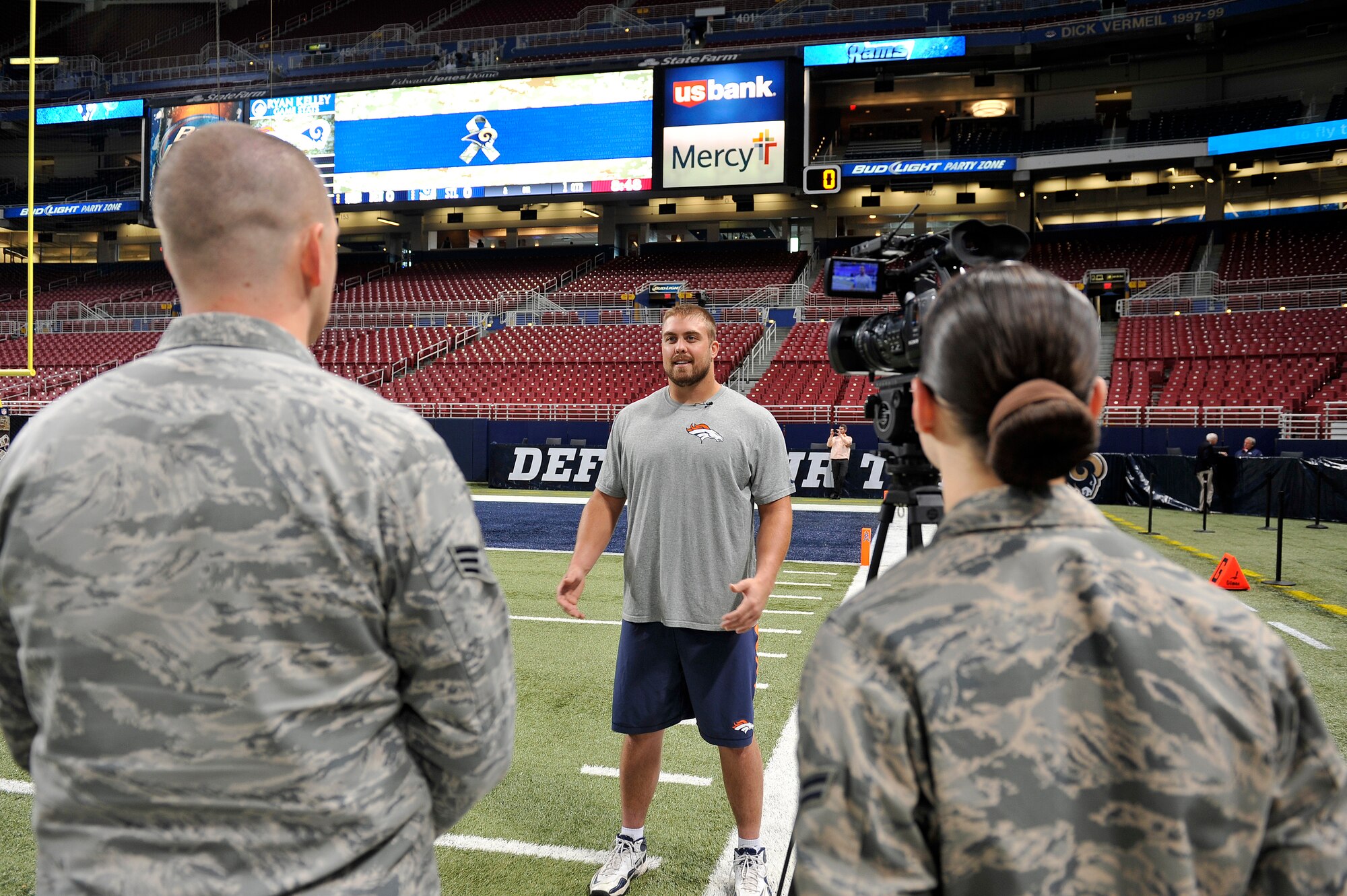 Senior Airman Timothy Kirchner and Airman 1st Class Kimberly O'Brien, Broadcasters from Scott Air Force Base, Ill., interview Ben Garland, a player for the Broncos football team, Edward Jones Dome, St. Louis, Nov. 16, 2014. He served as an Air Force officer at Scott AFB, Ill., prior to joining the football team. Servicemembers of all the military branches were represented and recognized for their service at this game, as a part of St. Louis Rams Military Appreciation Day events during the Rams versus Denver Broncos game. (U.S. Air Force photo by Airman 1st Class Erica Crossen)