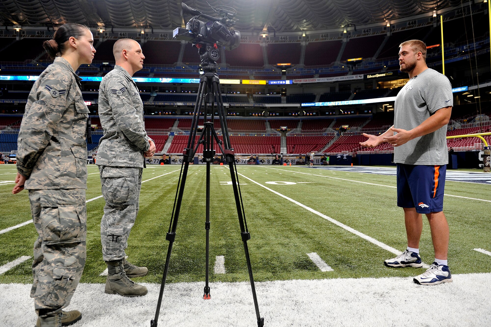 Senior Airman Timothy Kirchner and Airman 1st Class Kimberly O'Brien, Broadcasters from Scott Air Force Base, Ill., interview Ben Garland, a player for the Broncos football team, Edward Jones Dome, St. Louis, Nov. 16, 2014. He served as an Air Force officer at Scott AFB, Ill., prior to joining the football team. Servicemembers of all the military branches were represented and recognized for their service at this game, as a part of St. Louis Rams Military Appreciation Day events during the Rams versus Denver Broncos game. (U.S. Air Force photo by Airman 1st Class Erica Crossen)