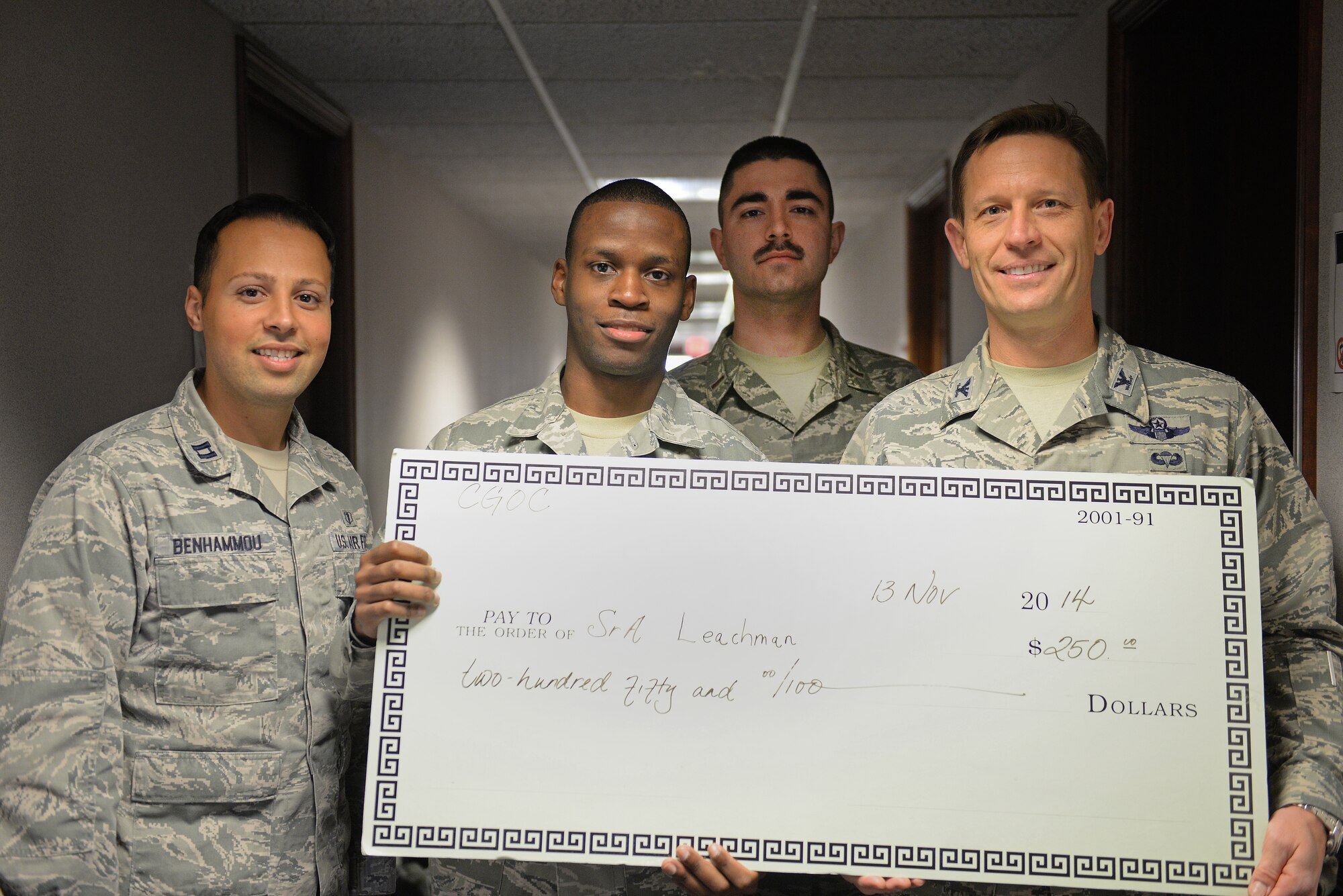 Senior Airman Demarcus Leachman, 375th Communications Support Squadron, recieved a Company Grade Officer's Council scholarship in the amount of 250 dollars, presented by Col. Gregory Green, 375th Air Mobility Wing Vice Commander, Capt. Mossaab Benhammou and 2nd Lt. Thomas Munson, representing CGOC, Nov. 13, 2014, Scott Air Force Base, Ill.. Winners of this scholarship are chosen because of their hard work and commitment to bettering themselves through education. (U.S. Air Force photo by Airman 1st Class Erica Crossen)