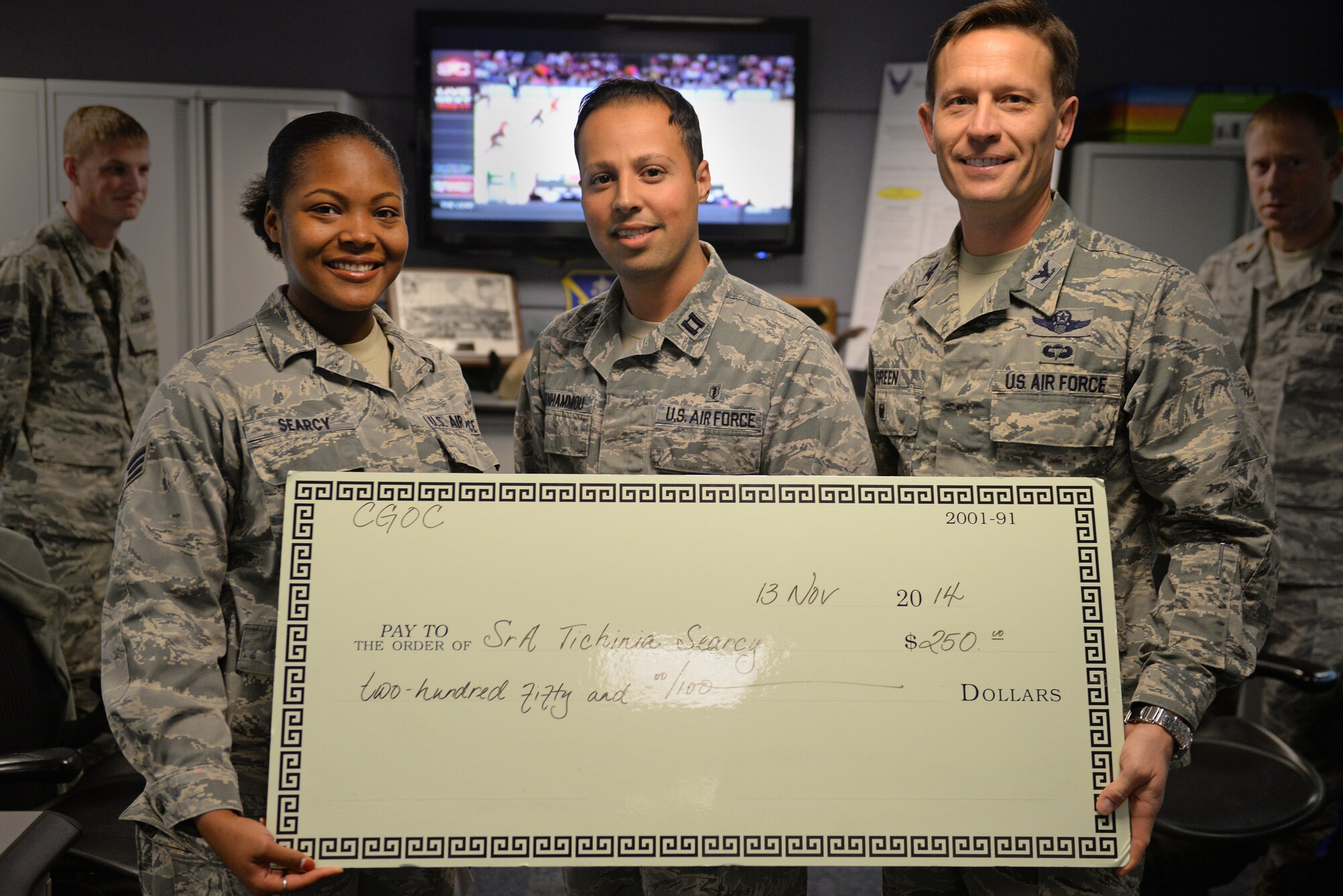 Senior Airman Tichinia Searcy, an 618th Tanker Airlift Control Center Weather Forecaster, recieved a Company Grade Officer's Council scholarship in the amount of 250 dollars, presented by Col. Gregory Green, 375th Air Mobility Wing Vice Commander, and Capt. Mossaab Benhammou, representing CGOC, Nov. 13, 2014, Scott Air Force Base, Ill.. Winners of this scholarship are chosen because of their hard work and commitment to bettering themselves through education. (U.S. Air Force photo by Airman 1st Class Erica Crossen)