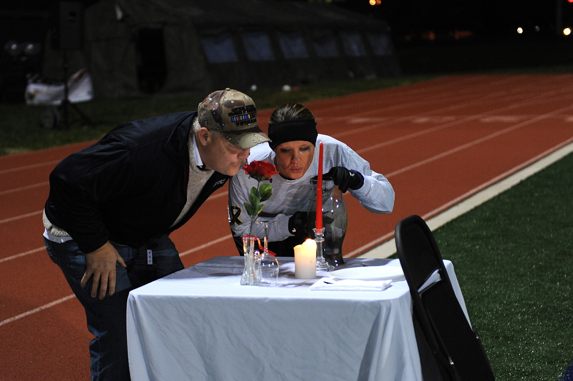 Staff Sgt. Nicole Brown Air Force Sergeants Association and Air Force veteran Tech. Sgt. William Wymore blow out a candle during the opening ceremony of the AFSA Veterans Day Vigil Run Nov. 7, 2014. The candle represents all veterans past and present. It is burned for the 24 hour duration of the run. Wymore is the veteran the run is dedicated to this year.  (U.S. Air Force photo/ Staff Sgt. Jonathan Fowler)