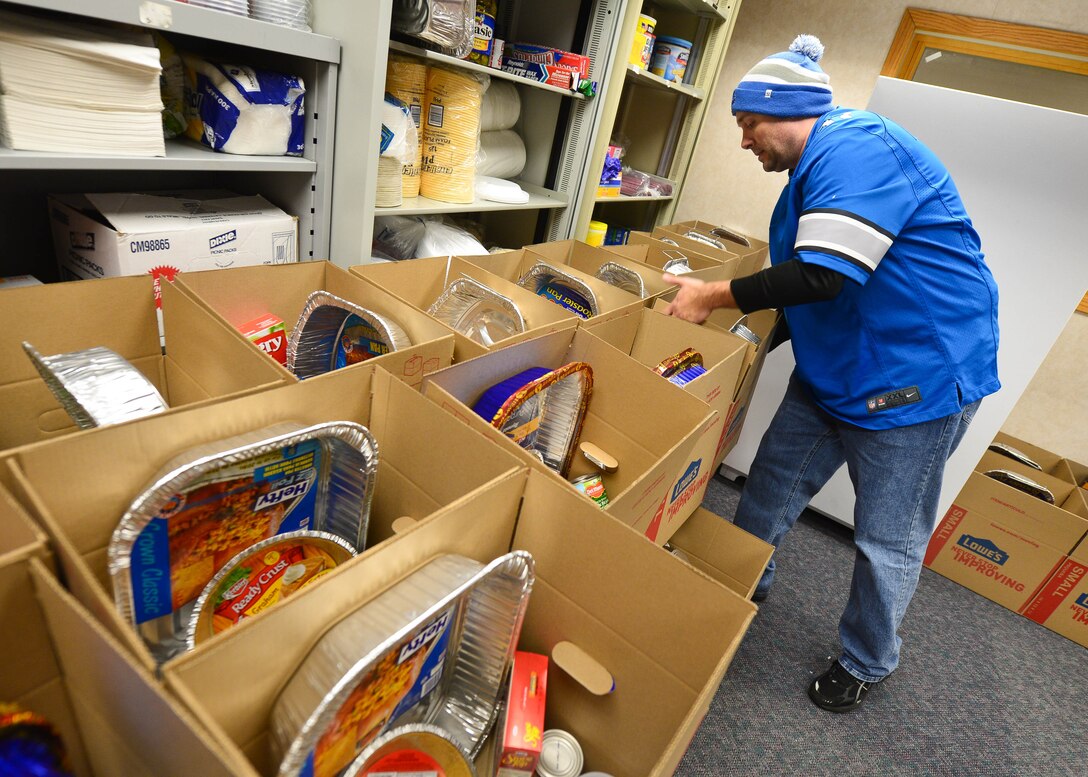Tech. Sgt. Ronald Twining, 28th Force Support Squadron Airman Leadership School instructor, stacks Thanksgiving meal baskets as part of Operation Warmheart at Ellsworth Air Force Base, S.D., Nov. 16, 2014. Every year Operation Warmheart provides free Thanksgiving meals to Airmen and their families with the help of the First Sergeants Council and volunteers. (U.S. Air Force photo by Senior Airman Zachary Hada/Released)