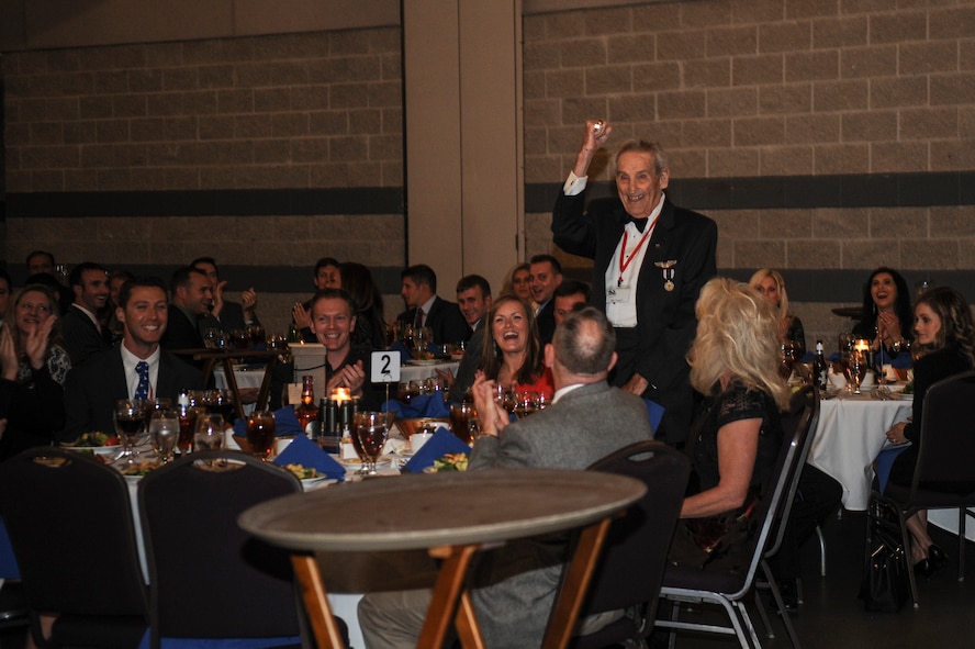 J.M. Taylor, a former 75th Fighter Squadron pilot and World War II veteran, shows his enthusiasm during his introduction at the 2014 Flying Tigers Reunion dinner Nov. 15, 2014, at the James H. Rainwater Conference Center in Valdosta, Ga. The three-day reunion allowed original WWII veterans the chance to share war stories with current and former Flying Tiger pilots. (U.S. Air Force photo by Andrea Jenkins/Released)