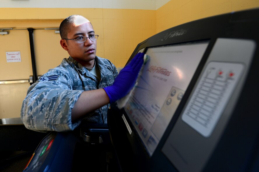 U.S. Air Force Senior Airman Steven Johnson, 20th Force Support Squadron fitness specialist, wipes down a treadmill at the 20th FSS Fitness and Health Center at Shaw Air Force Base, S.C., Nov. 19, 2014. At least once a week, each of the approximately 100 pieces of fitness equipment are wiped down with sanitizer to ensure the cleanliness of the machine and health of the user. (U.S. Air Force photo by Airman 1st Class Jensen Stidham/Released)