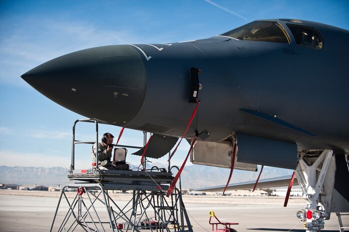 A crew chief from the 34th Aircraft Maintenance Unit, Ellsworth Air Force Base, S.D., reviews aircraft maintenance forms and communicates with another crew chief in the cockpit of a B-1B Lancer assigned to the 34th Bomb Squadron, Ellsworth AFB, during Green Flag-West 15-02 at Nellis AFB, Nev., Nov. 18, 2014. Green Flag-West is a realistic air-land integration combat training exercise involving the air forces of the U.S. and its allies, is primarily conducted in conjunction with U.S. Army National Training Center exercises at Fort Irwin, Calif. (U.S. Air Force photo by Staff Sgt. Siuta B. Ika)