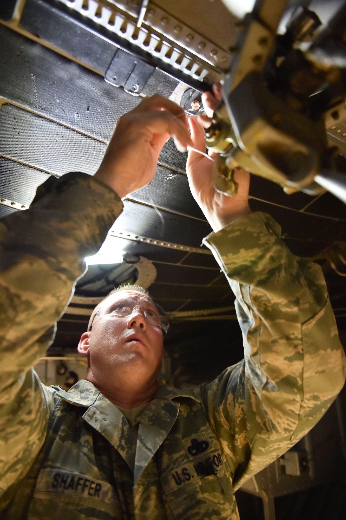 Master Sgt. Ed Shaffer, an aircraft maintenance craftsman with the 910th Aircraft Maintenance Squadron, secures safety wire under the nose of a C-130 Hercules aircraft here, Nov. 6, 2014. The safety wiring was attached as part of an armor plating system installation. Youngstown is the second base to receive a test version of the new system, designed for easier and more secure installation and better protection for aircrew members. (U.S. Air Force photo/Eric M. White)