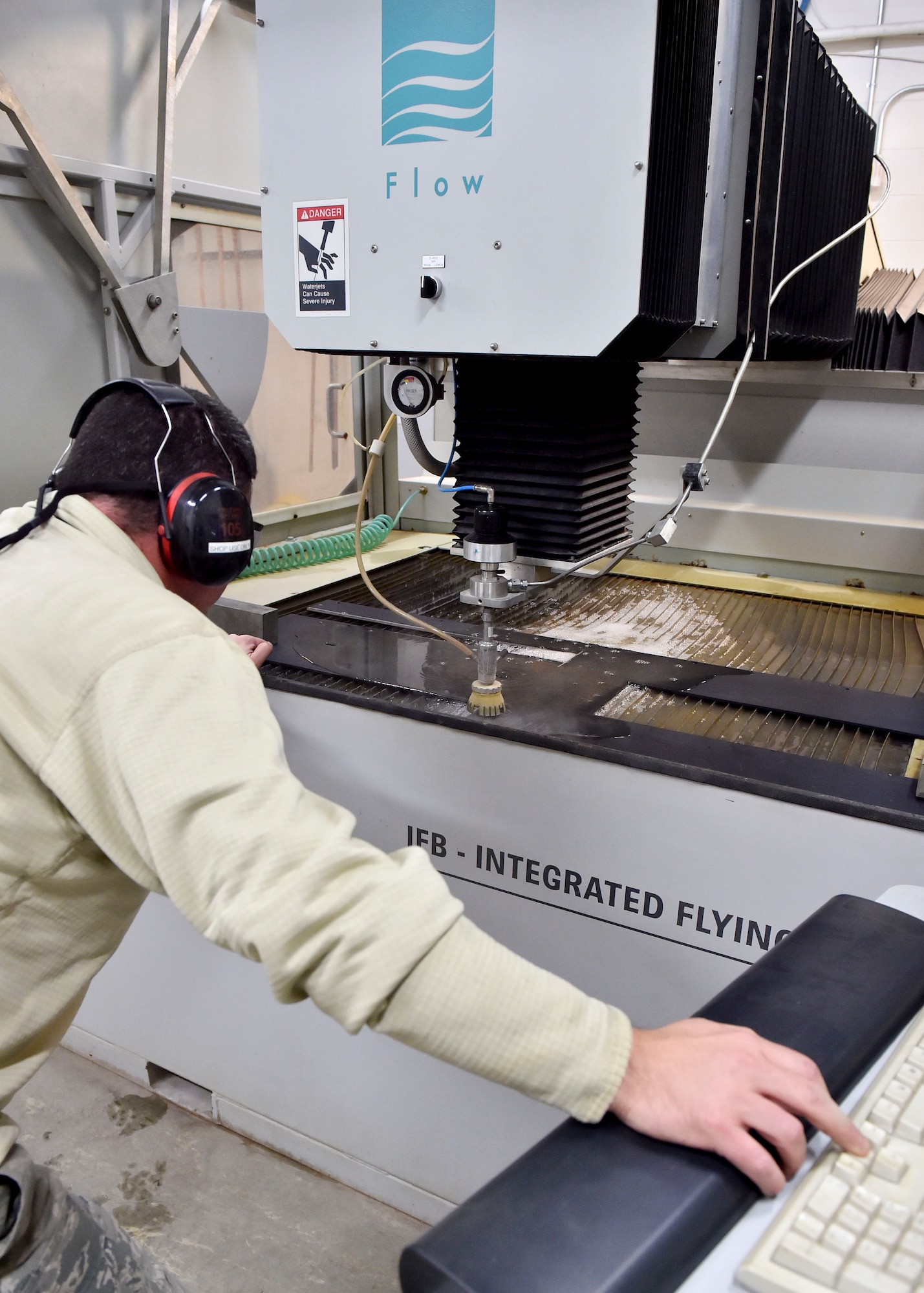 Tech. Sgt. Ross Gordon, an aircraft metals tech craftsman with the 910th Maintenance Squadron, operates a water jet cutting machine to trim a piece of metal here, Nov. 6, 2014. The metal is part of a new armor plating system installed on a Youngstown C-130 Hercules the week of Nov. 2. Youngstown is the second base to receive a test version of the new system, designed for easier and more secure installation and better protection for aircrew members. (U.S. Air Force photo/Eric M. White)
