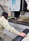Tech. Sgt. Ross Gordon, an aircraft metals tech craftsman with the 910th Maintenance Squadron, operates a water jet cutting machine to trim a piece of metal here, Nov. 6, 2014. The metal is part of a new armor plating system installed on a Youngstown C-130 Hercules the week of Nov. 2. Youngstown is the second base to receive a test version of the new system, designed for easier and more secure installation and better protection for aircrew members. (U.S. Air Force photo/Eric M. White)