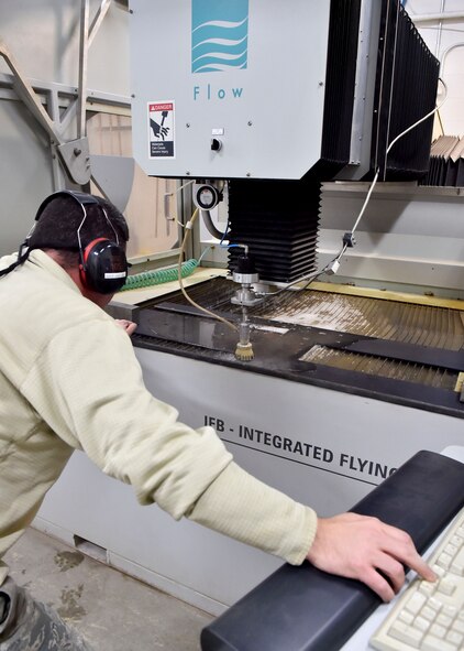 Tech. Sgt. Ross Gordon, an aircraft metals tech craftsman with the 910th Maintenance Squadron, operates a water jet cutting machine to trim a piece of metal here, Nov. 6, 2014. The metal is part of a new armor plating system installed on a Youngstown C-130 Hercules the week of Nov. 2. Youngstown is the second base to receive a test version of the new system, designed for easier and more secure installation and better protection for aircrew members. (U.S. Air Force photo/Eric M. White)