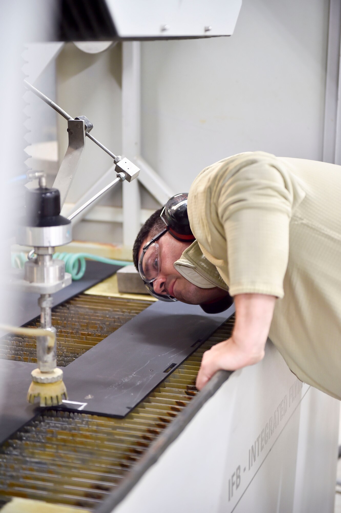 Tech. Sgt. Ross Gordon, an aircraft metals tech craftsman with the 910th Maintenance Squadron, operates a water jet cutting machine to trim a piece of metal here, Nov. 6, 2014. The metal is part of a new armor plating system installed on a Youngstown C-130 Hercules the week of Nov. 2. Youngstown is the second base to receive a test version of the new system, designed for easier and more secure installation and better protection for aircrew members. (U.S. Air Force photo/Eric M. White)