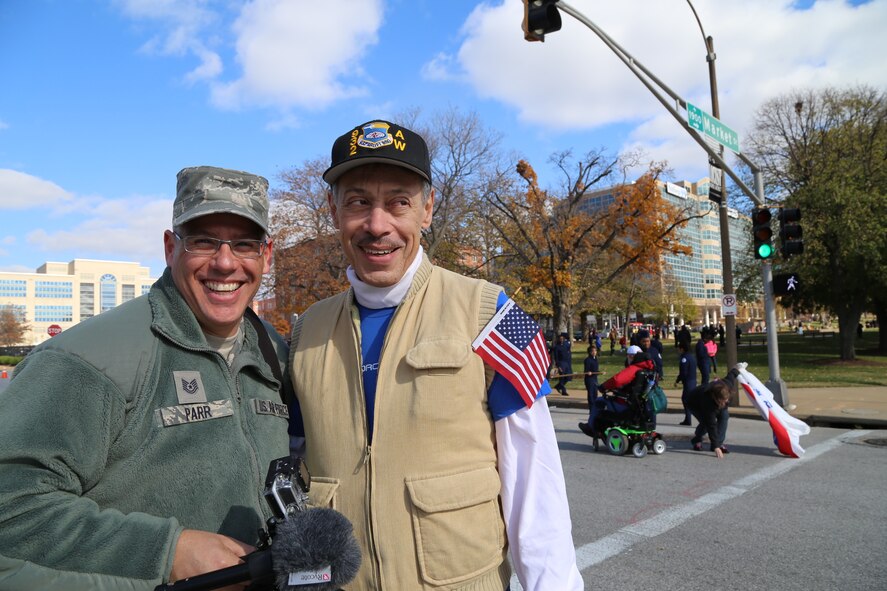 Reunited after a season, public affairs specialist Tech. Sgt. Christopher Parr catches up to retired Tech. Sgt. Dan Oliver, formerly of the same office while on location at the St. Louis Veterans parade in November.  Sergeant Oliver was proudly wearing the 932nd Airlift wing hat and the Air Force Reserve recruiting blue shirt underneath to stay warm during the chilly day in downtown. (U.S. Air Force Photo/Maj. Stan Paregien) 