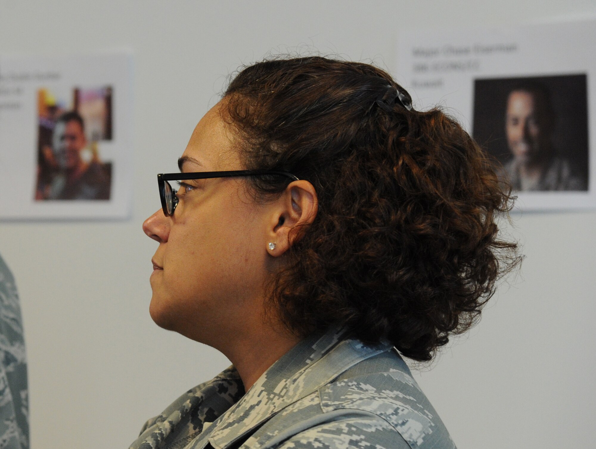 Photos of deployed servicemembers who will receive the package assembled by Master Sgt. Warrell Shaklin hang behind her during the Air Force District of Washington care package event at Joint Base Andrews, Md., Nov. 17, 2014. Four times a year, the AFDW unit deployment manager, Annette Bonaro, coordinates the creation of themed care packages for each Airman deployed from the command and those adopted by the command. Shanklin is the AFDW financial management accounting operations deputy chief. (U.S. Air Force photo/Master Sgt. Tammie Moore)