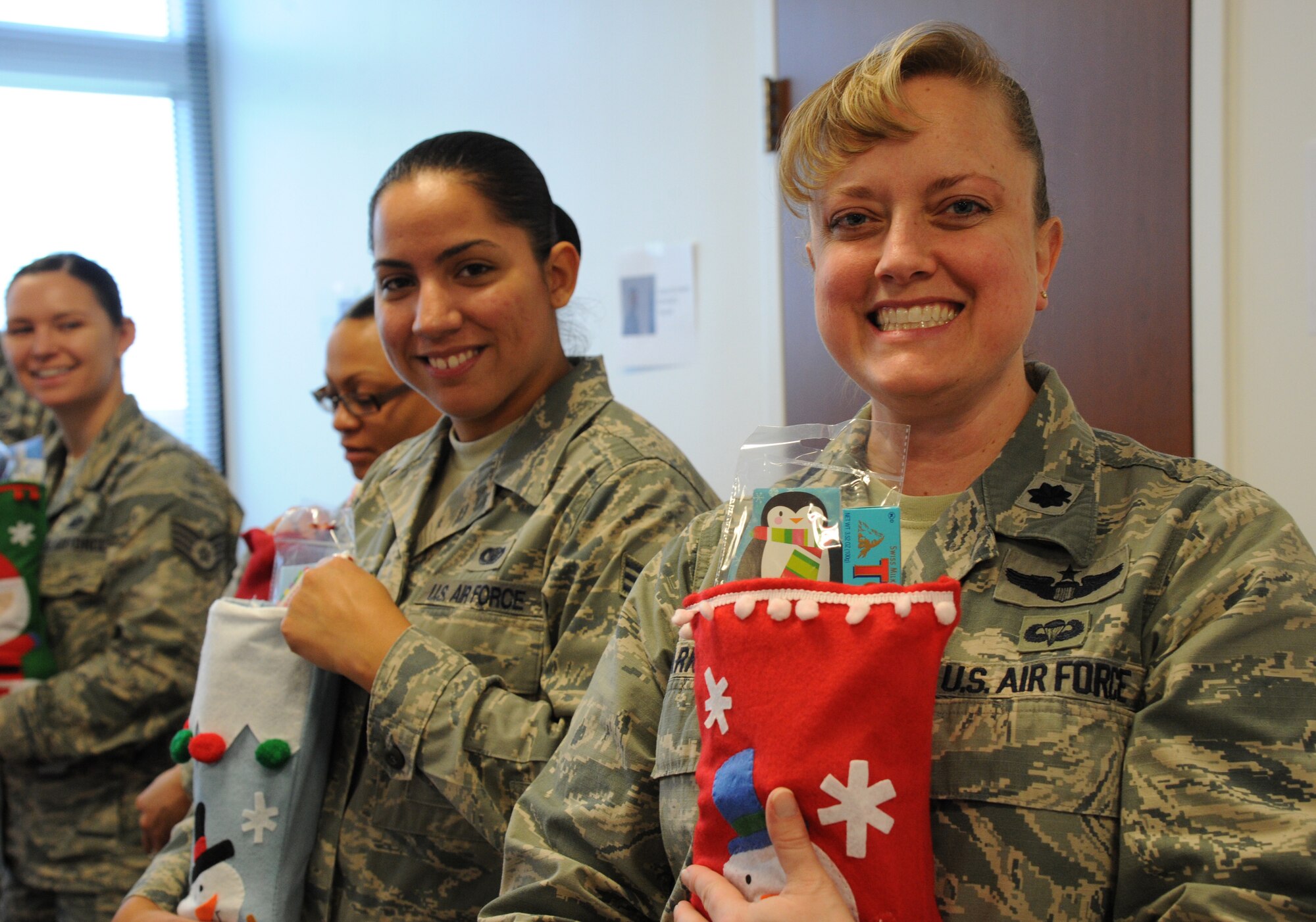 Lt. Col. Michelle Barker and Senior Airman Krystal Elmore show off stockings they stuffed for care packages being sent to Airmen deployed from the Air Force District of Washington and those adopted by the command during a care package packing event at Joint Base Andrews, Md., Nov. 17, 2014. Individuals from the unit along with local businesses, churches, schools, and people connected to AFDW from across the country donated snacks, beverage mixes, and more for the packages. Barker is the AFDW Commander’s Action Group director. Elmore is an AFDW Ceremonies and Protocol specialist. (U.S. Air Force photo/Master Sgt. Tammie Moore)