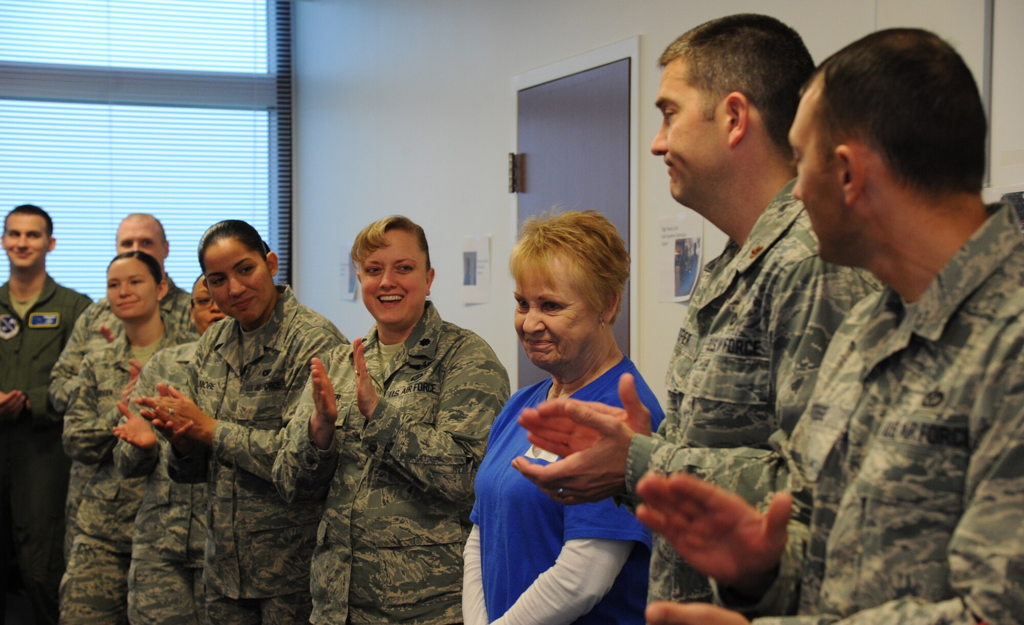 Airmen from the Air Force District of Washington recognize the role Maggie Landeck played in helping to ensure the shipment of care packages from the command was successful at Joint Base Andrews, Md., Nov. 17, 2014. This is the 18th AFDW shipment of command care packages. Landeck spent hours preparing the donated items for packing and making homemade refreshments for the packers. Landeck is the mother of Annette Bonaro, the AFDW unit deployment manager. (U.S. Air Force photo/Master Sgt. Tammie Moore)