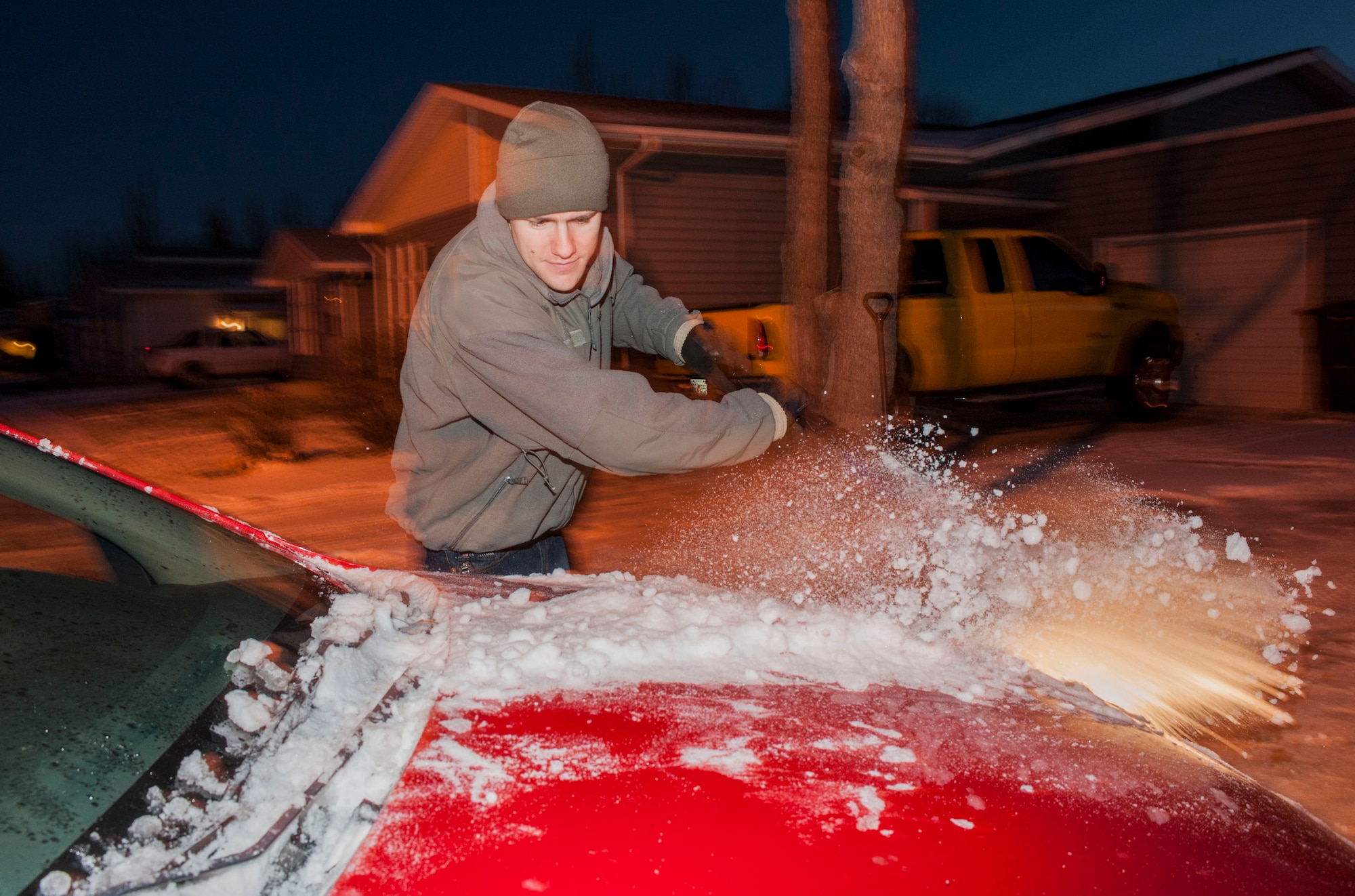 Senior Airman Thomas Stang, 5th Security Forces Squadron installation entry controller, clears a vehicles windshield before driving on Minot Air Force Base, N.D. Nov. 13, 2014. During the winter months, it is crucial for drivers to ensure they clear all of the windows on their vehicle before driving to avoid accidents.  (U.S. Air Force photo/Senior Airman Stephanie Morris)