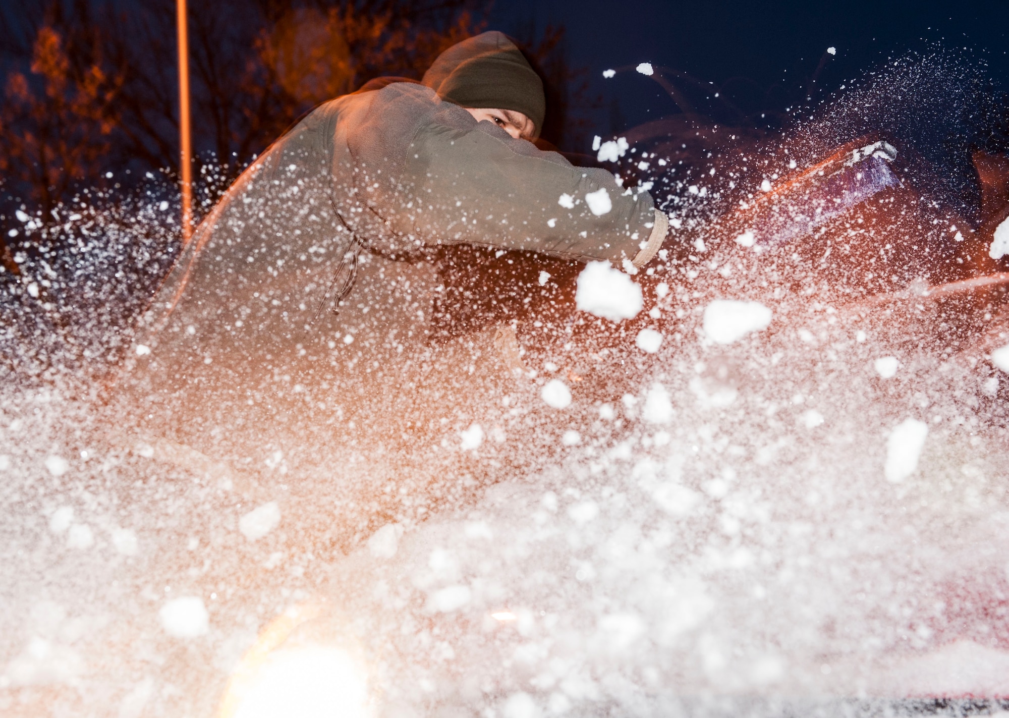 Senior Airman Thomas Stang, 5th Security Forces Squadron installation entry controller, clears a vehicles windshield before driving on Minot Air Force Base, N.D. Nov. 13, 2014. During the winter months, it is crucial for drivers to ensure they clear all of the windows on their vehicle before driving to avoid accidents.  (U.S. Air Force photo/Senior Airman Stephanie Morris)