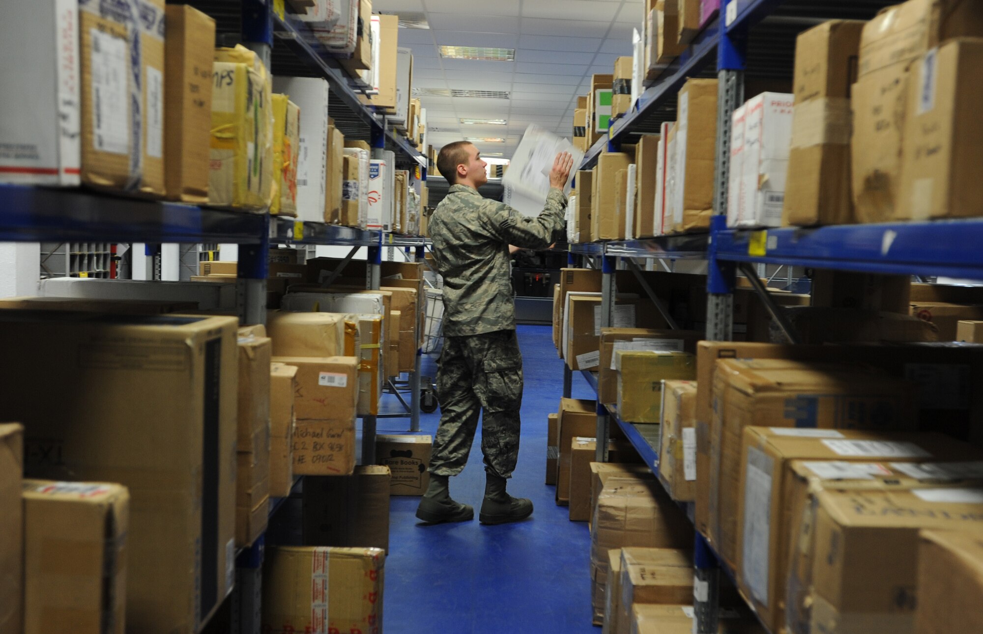 Senior Airman Thayne Rooney, 86th Communications Squadron postal specialist, retrieves a package off storage shelves for a customer March 27, 2014, at Ramstein Air Base, Germany. The 78 members of the North Side Post Office ensure packages and other mail leave and arrive at Ramstein promptly by using quality service, pride in their work and motivation.(U.S. Air Force photo/Airman 1st Class Holly Mansfield)