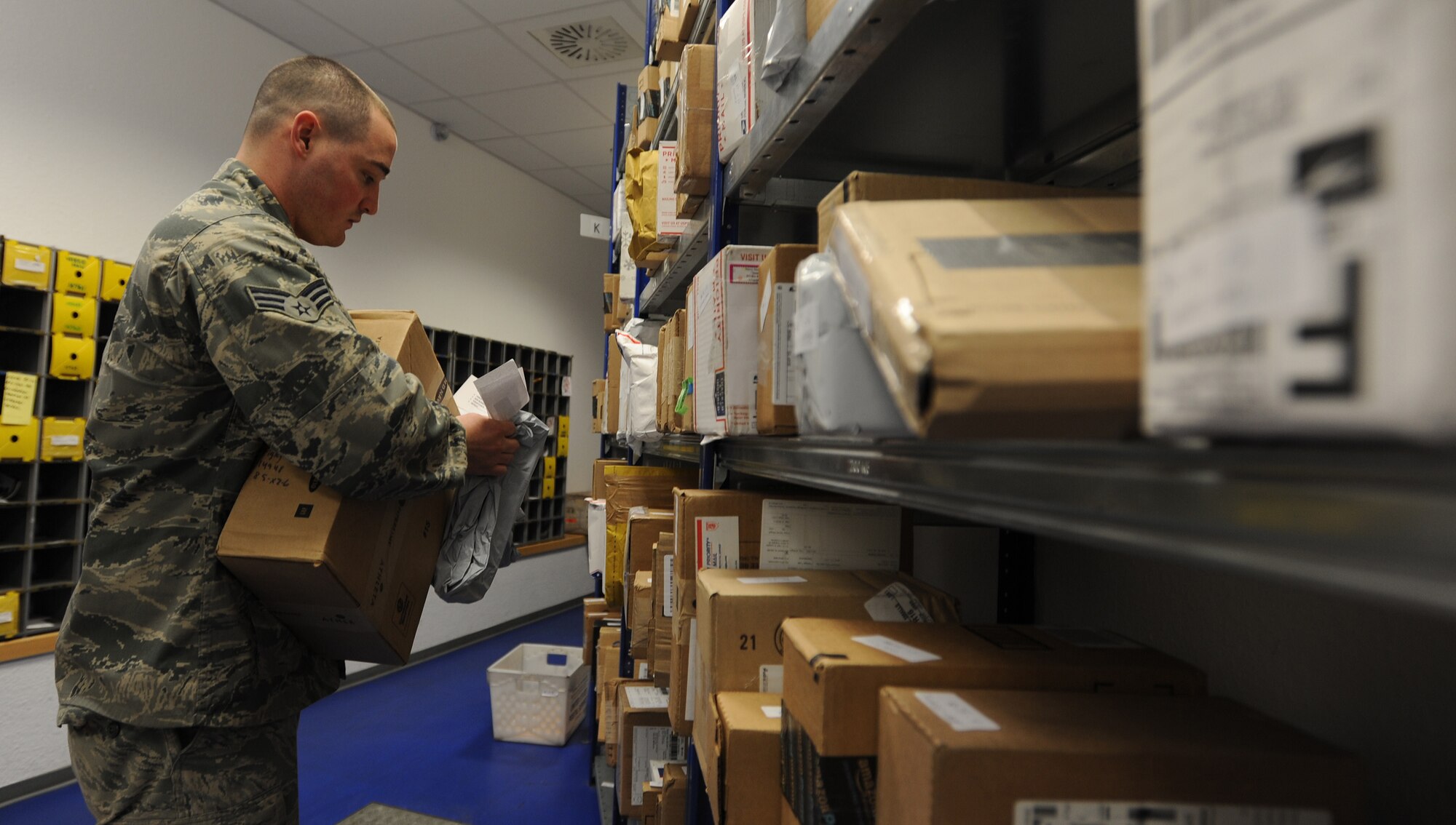 Senior Airman John Brooks, 86th Communications Squadron postal specialist, retrieves a package off storage shelves for a customer March 27, 2014, at Ramstein Air Base, Germany. The 78 members of the North Side Post Office ensure packages and other mail leave and arrive at Ramstein promptly by using quality service, pride in their work and motivation.(U.S. Air Force photo/Airman 1st Class Holly Mansfield)