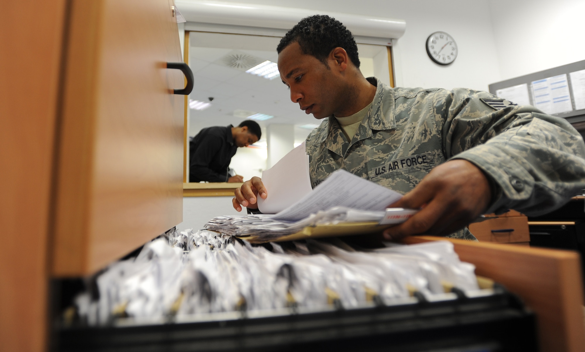 Staff Sgt. James Whyte, 86th Communications Squadron customer service NCOIC, files paperwork at the customer service desk March 27, 2014, at Ramstein Air Base, Germany. The 78 members of the North Side Post Office ensure packages and other mail leave and arrive at Ramstein promptly by using quality service, pride in their work and motivation.(U.S. Air Force photo/Airman 1st Class Holly Mansfield)