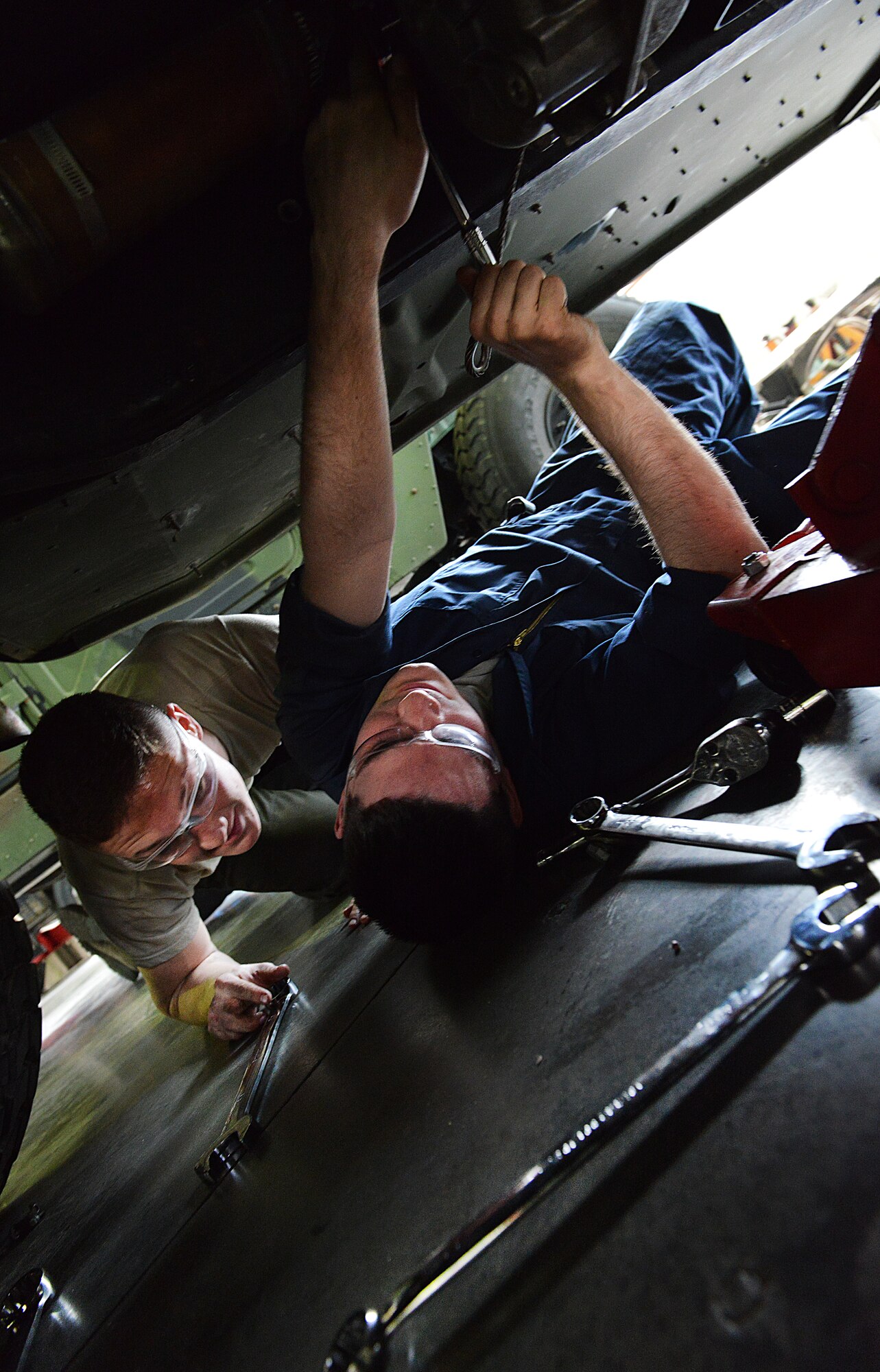 Airman 1st Class, Lorne Abshire (right) and Brock Taczak, 86th Vehicle Readiness Squadron light vehicle mechanic, loosen the bolts from the transmission of a Humvee, April 1, 2014 at Ramstein Air Base, Germany. (U.S. Air Force photo/ Airman Dymekre Allen)