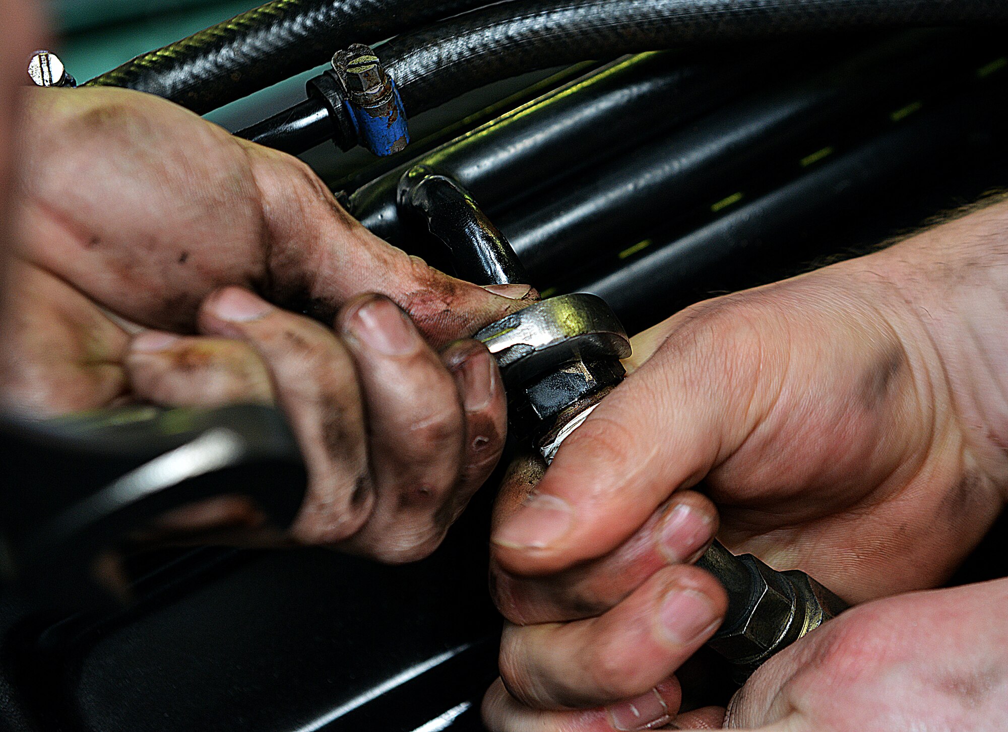 Senior Airman Brian Klockow (right) and Airman 1st Class Frederick Vogelgesang, 86th Vehical Readiness Squadron light vehical mechanics, tighten the radiator hoses of a Humvee, April 1, 2014 at Ramstein Air Base, Germany. (U.S. Air Force photo/ Airman Dymekre Allen)
