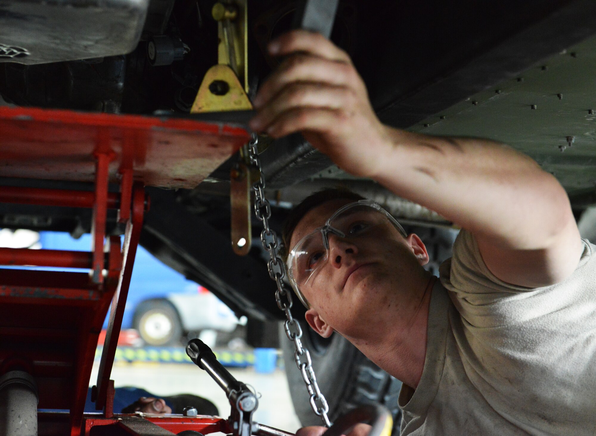 Airman 1st Class Brock Taczak, 86th Vehicle Readiness Squadron light vehicle mechanic, attaches a jack to Humvee before removing the transmission April 1, 2014 at Ramstein Air Base, Germany. (U.S. Air Force photo/ Airman Dymekre Allen)