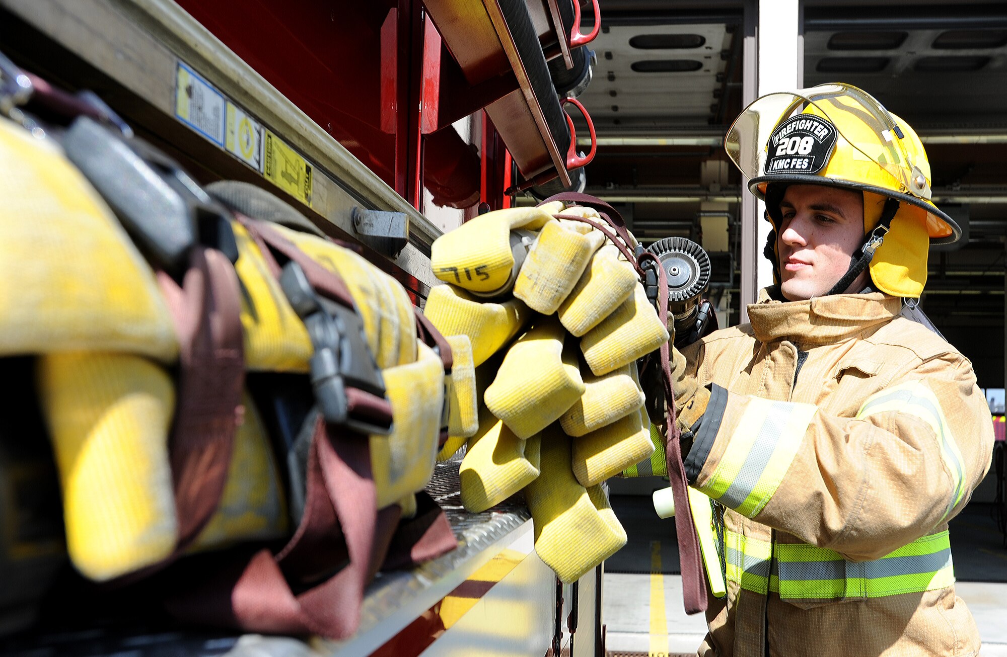 Airman 1st Class William Campbell, 86th Civil Engineer Squadron fire fighter, puts a fire hose on a fire truck April 2, 2014, at Ramstein Air Base, Germany. The Ramstein Fire Department recently received the Air force Fire Department of the Year Award for its members’ excellence in fire safety. (U.S. Air Force photo/Airman 1st Class Holly Mansfield)