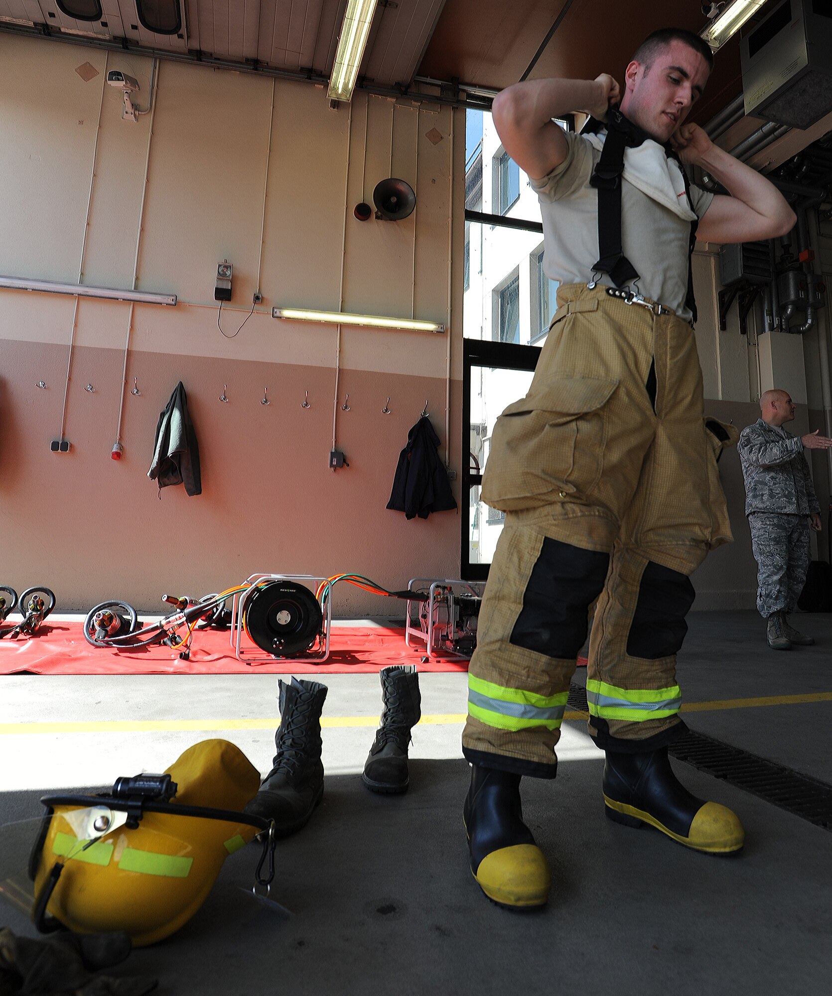 Airman 1st Class William Campbell, 86th Civil Engineer Squadron fire fighter, dawns safety gear before inspecting equipment used during rescue situations April 2, 2014, at Ramstein Air Base, Germany. The Ramstein Fire Department recently received the Air force Fire Department of the Year Award for its members’ excellence in fire safety. (U.S. Air Force photo/Airman 1st Class Holly Mansfield)