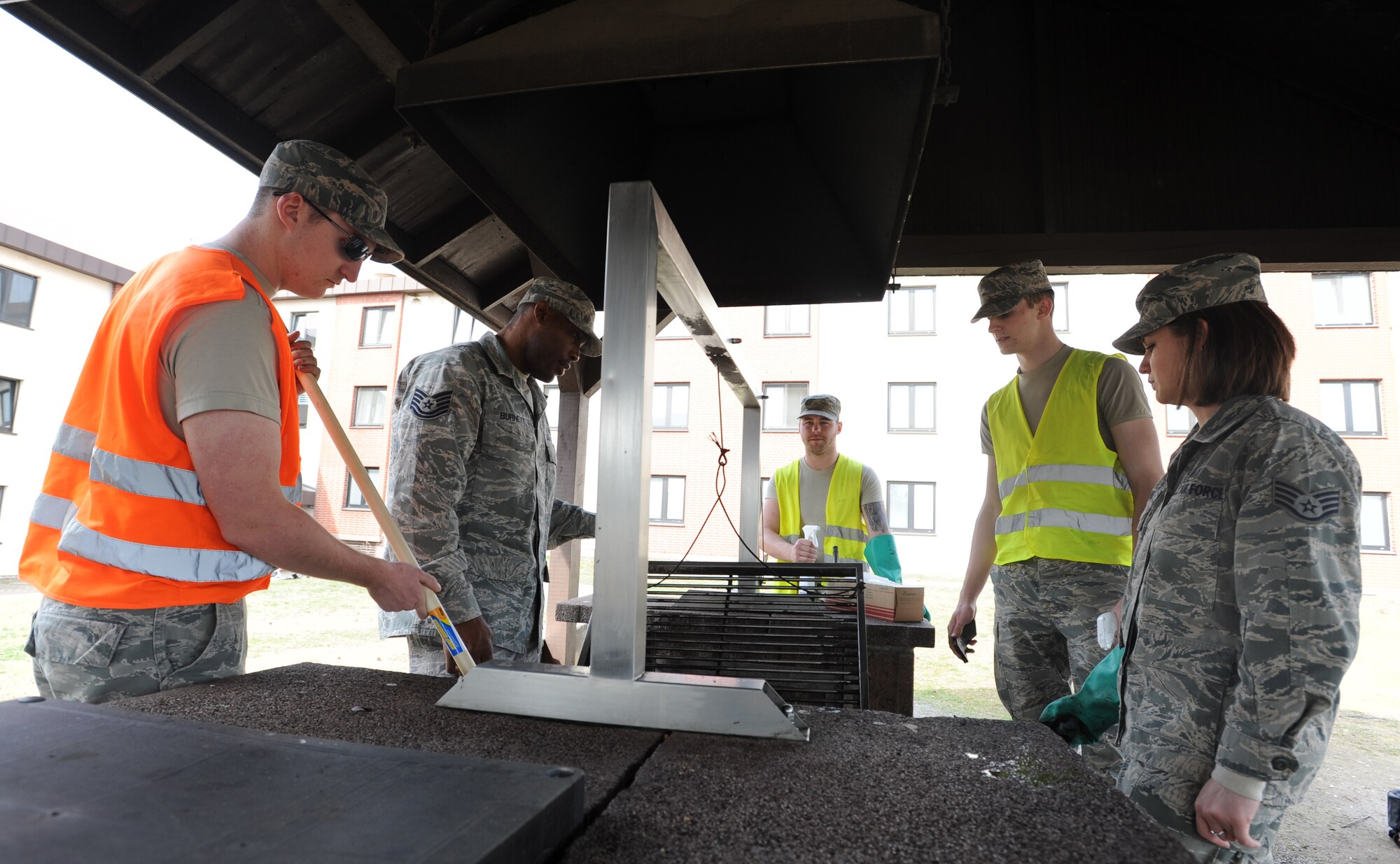 Airmen Dorm Leaders from the Ramstein Dorm Reception Center assist Airmen assigned to bay orderly with cleaning a grill April 2, 2014, at Ramstein Air Base, Germany. ADLs help Airmen living in the dorms with their needs, such as fixing broken furniture and loaning carpet cleaners. (U.S. Air Force photo/Airman 1st Class Holly Mansfield)