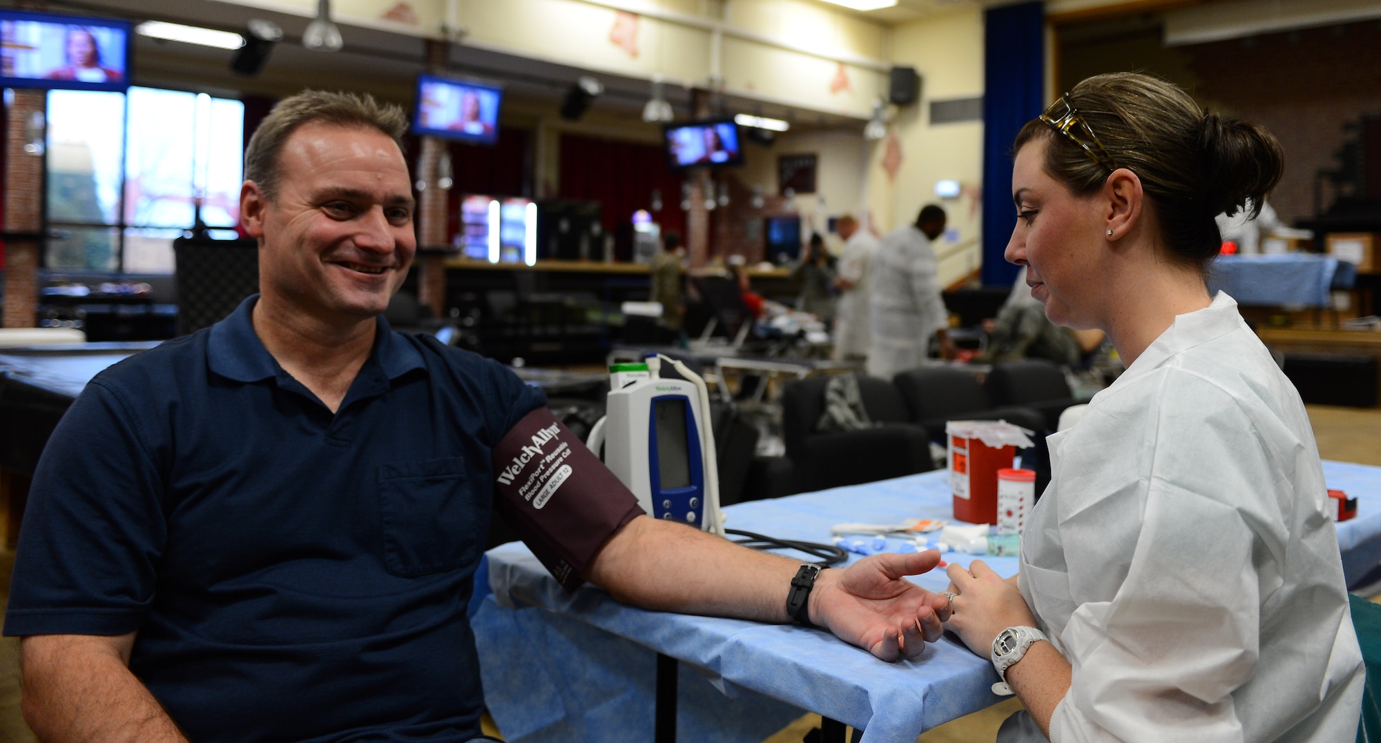 A blood donor gets his blood pressure taken by a Landstuhl Regional Medical Center laboratory technician during an Armed Services Blood Program blood drive at the Brick House Community Center on Spangdahlem Air Base, Germany, Nov. 18, 2014. The ASBP was established more than 60 years ago as a joint field operating agency. (U.S. Air Force photo by Airman 1st Class Luke Kitterman/Released)