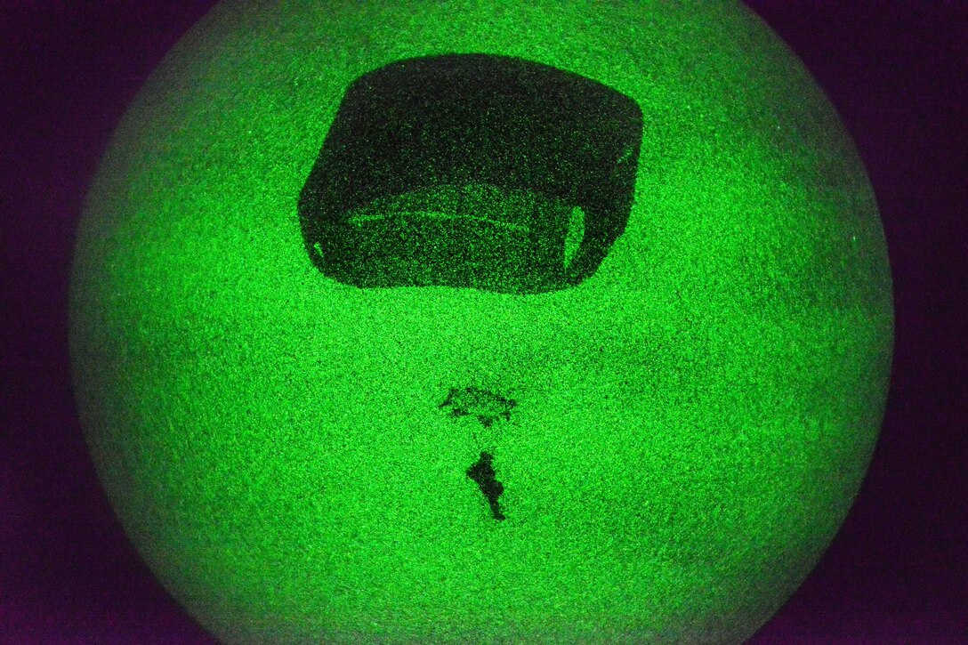 As seen through a night-vision device, a U.S. paratrooper descends to Juliet Drop Zone in Pordenone, Italy, Nov. 18, 2014.