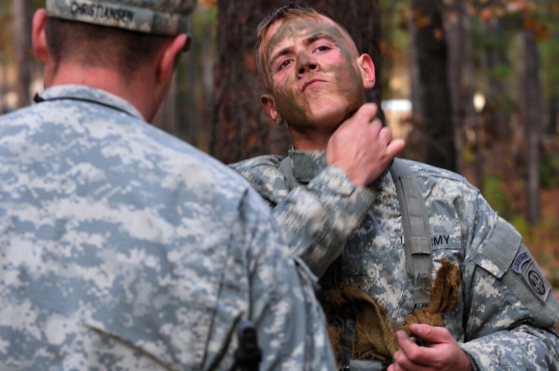 Army Pfc. Shawn Becker camouflages himself during expert infantry badge testing on Fort Bragg, N.C., Nov. 18, 2014. Becker is an infantryman assigned to the 82nd Airborne Division's 2nd Battalion, 325th Airborne Infantry Regiment, 2nd Brigade Combat Team.