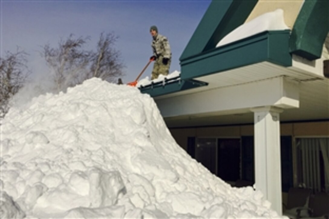 A New York National Guard airman removes snow from the roof of the Eden Heights Assisted Living Facility in West Seneca, N.Y., Nov. 19, 2014. The airman is assigned to the 107th Airlift Wing based in Niagara Falls, N.Y.