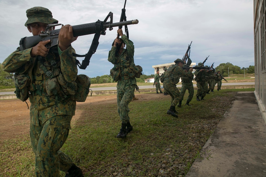 Members of the Royal Brunei Land Force and U.S. Marines practice military operations on urbanized terrain tactics Nov. 10 at the Penanjong Garrison, Tutong, Brunei. Service members participated in MOUT training as part of Cooperation Afloat Readiness and Training 2014 to learn tactics for operating in urban areas such as towns and cities. CARAT maritime exercise series promotes regional security cooperation, mutual understanding, and enhances interoperability among participating forces. The Royal Brunei Land Force service members are with 1st Battalion, RBLF. The U.S. Marines are with 2nd Battalion, 9th Marine Regiment currently assigned to 4th Marine Regiment, 3rd Marine Division, III Marine Expeditionary Force under the unit deployment program.